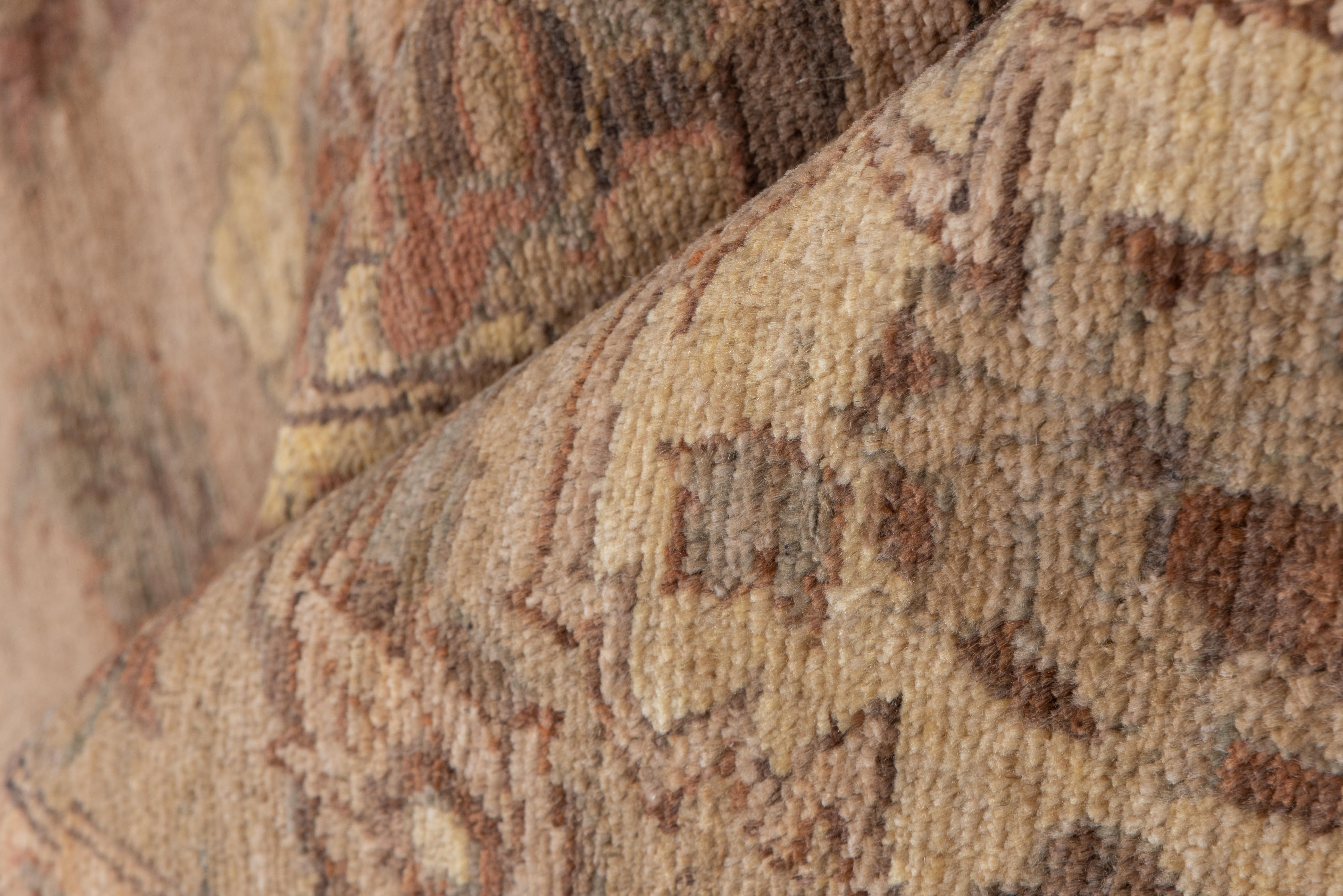 This vintage Sultanabad rug features a warmly faded clay-toned field layered with an intricate network of scrolling vines, palmettes, and rosettes in hues of olive, cocoa, taupe, and golden beige. The design is arranged in a relaxed yet balanced