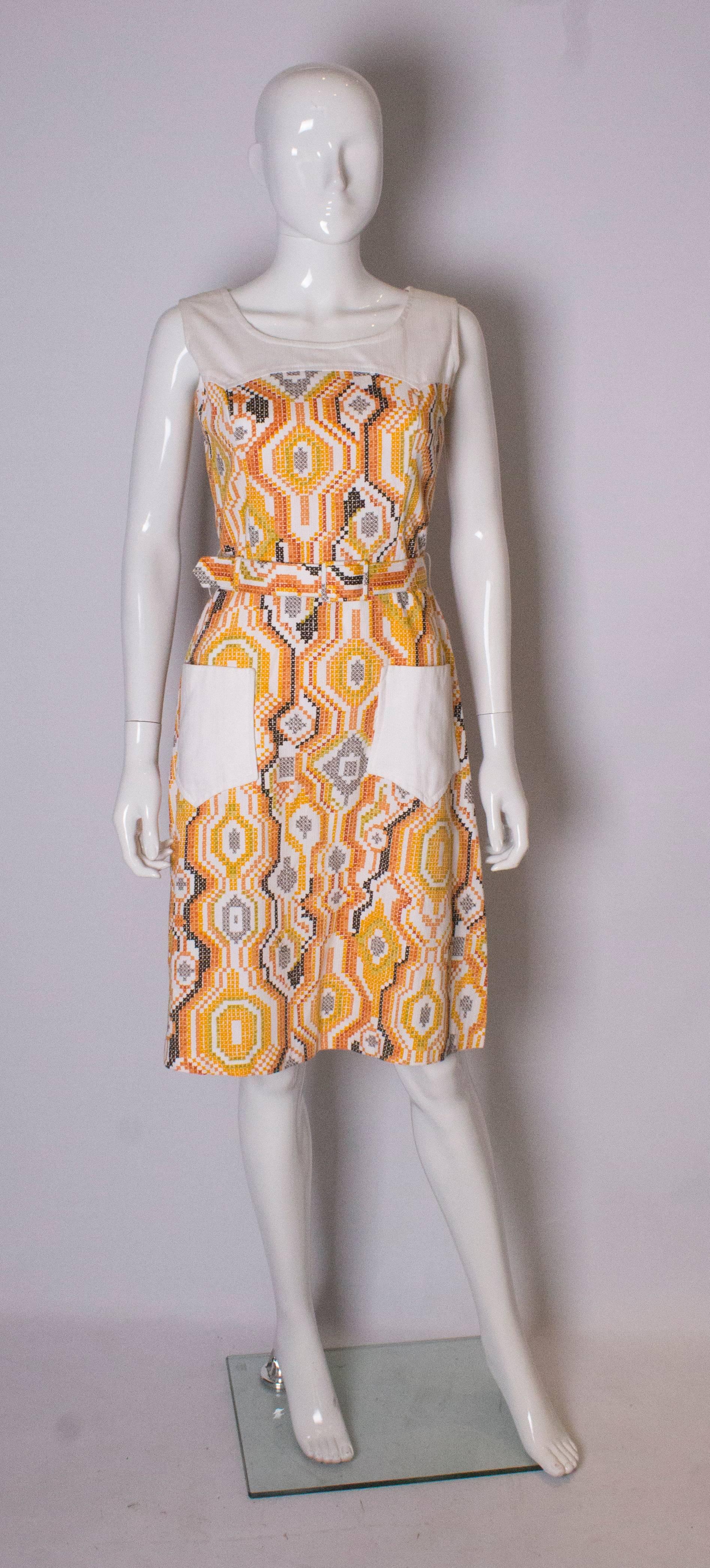 A great vintage Summer  dress by D L Barron. It is in a fun print of white, yellow and brown, with two large white pockets.
