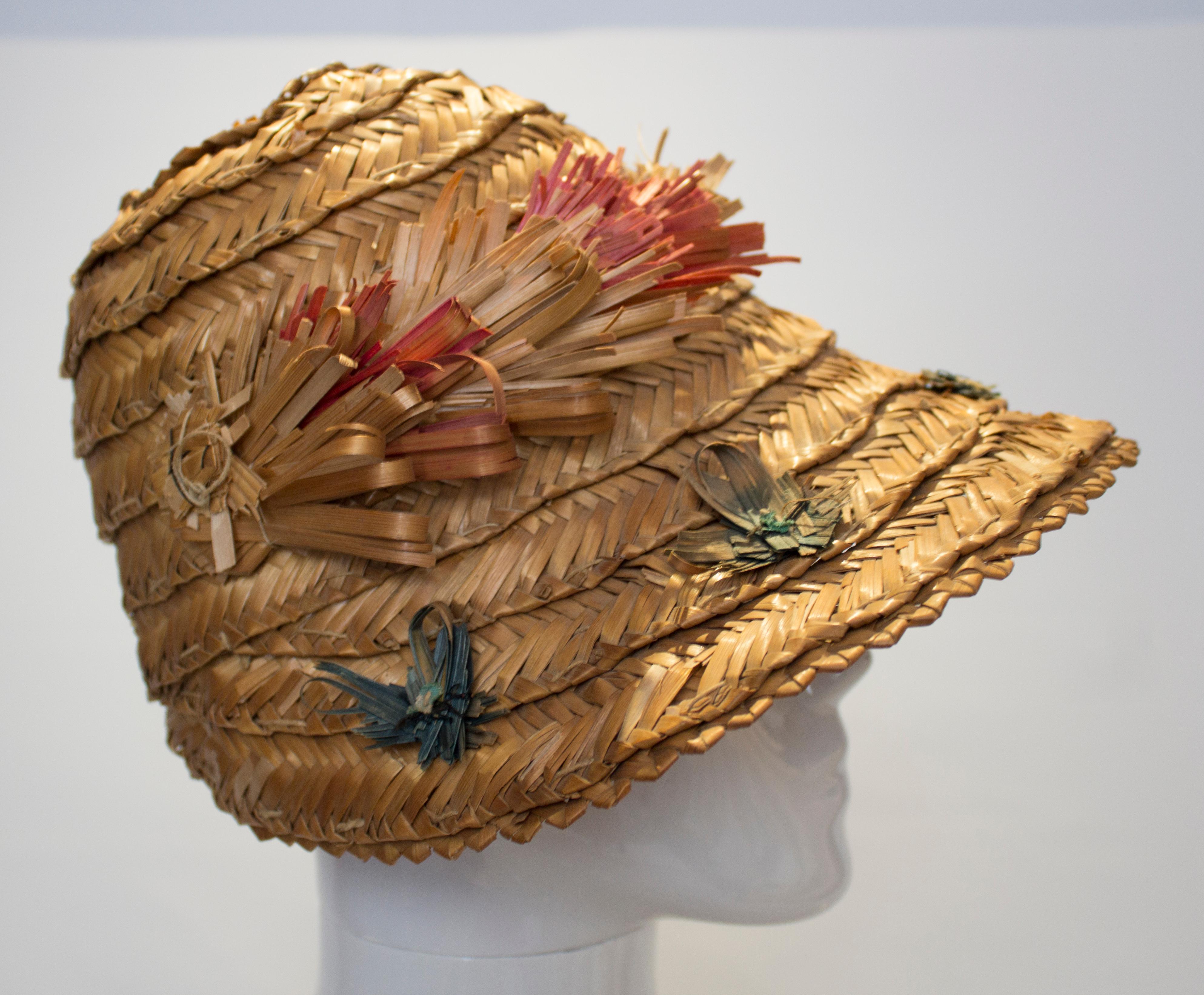  A fun vintage hat for Summer. The hat has a wonderful shape with a subtle peak. In a natural colour it has a band of fringed straw as decoration.Measurements: internal circumference 22'', height 6 1/2''.