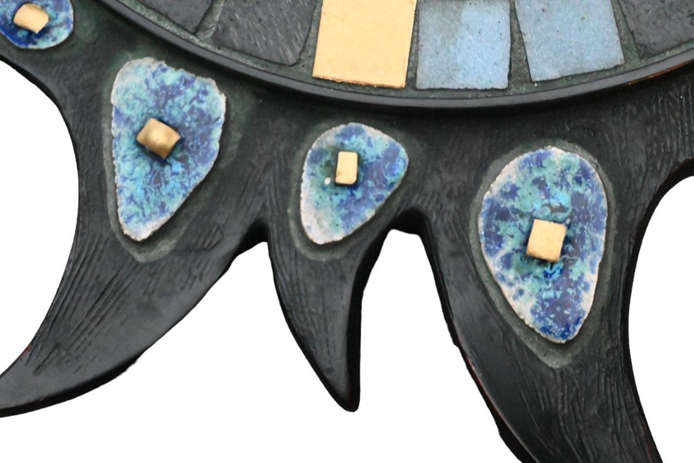 Questo splendido specchio convesso vintage a raggiera presenta accenti in ceramica smaltata blu e dettagli in rame su resina di qualità con un supporto in legno. Una creazione con marcature visibili in olandese e francese: 