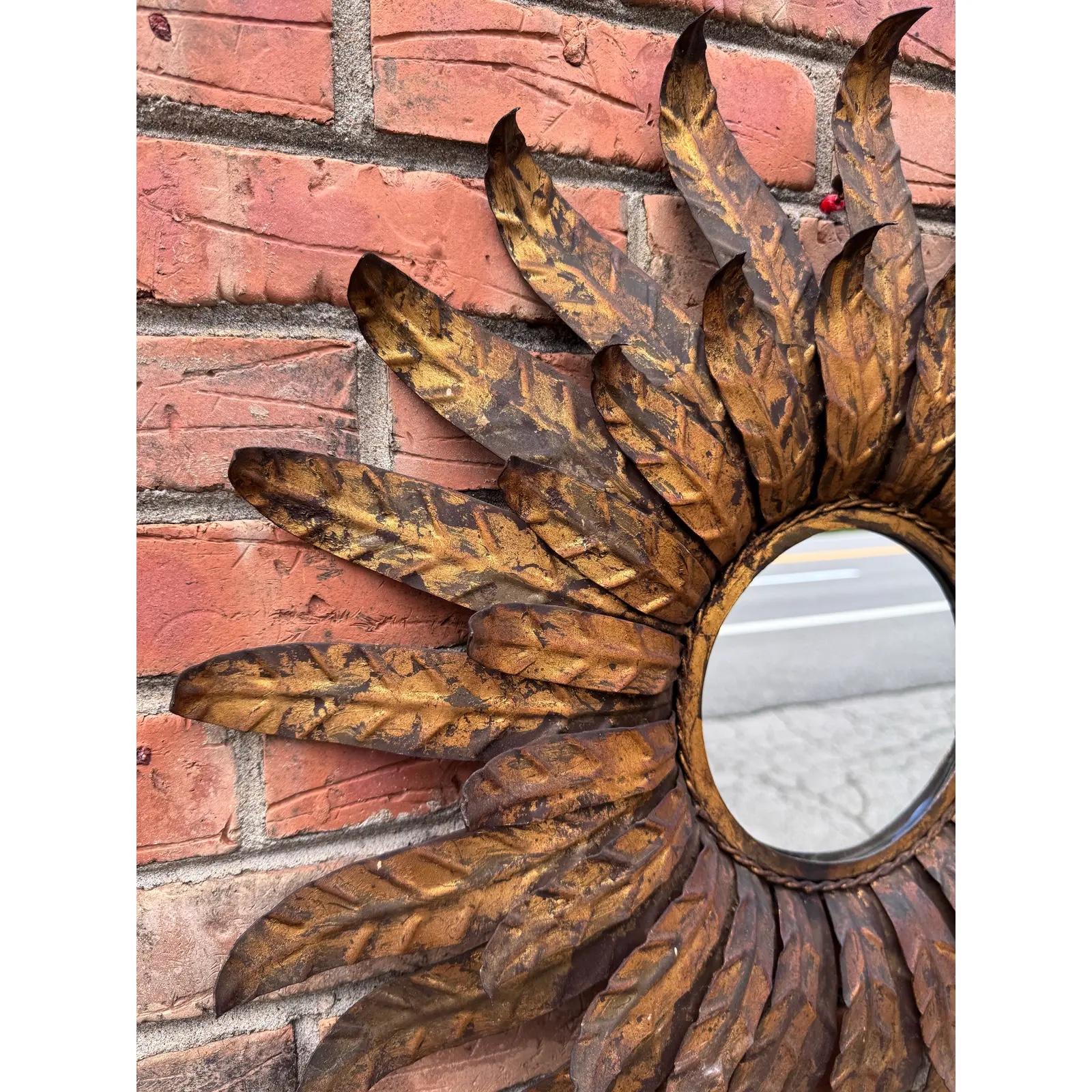 Questo bellissimo specchio a raggiera di metà secolo proviene dalla Spagna e dona una sobria eleganza alla tua stanza. Lo specchio piatto è completamente intatto, con alcuni difetti dovuti all'età. La sua cornice in legno dorato dona lucentezza al