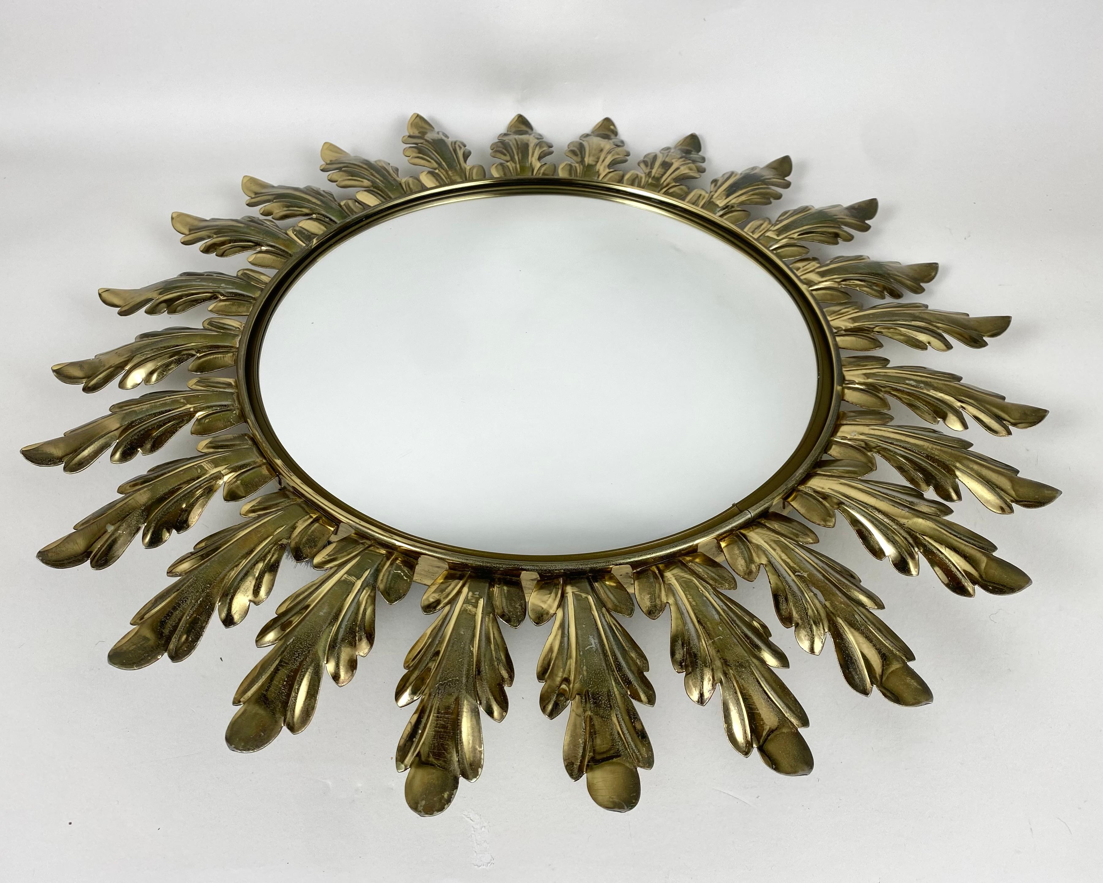 A beautiful Sunburst vintage wall mirror with a metal-mounted frame and a convex mirror plate.

The sun is made of gold-colored metal, with a pattern of oak leaves.

Manufactured in Belgium, by Deknudt, 1950-60s.

Our impressively sized handcrafted