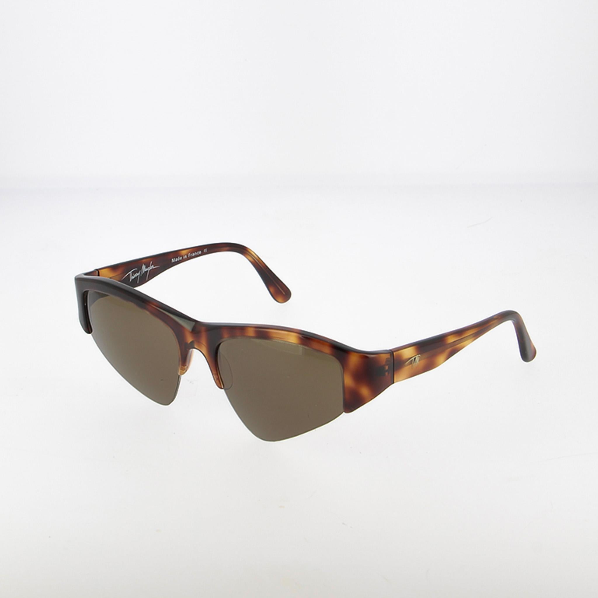 Descubre una de las creaciones de gafas más icónicas de Thierry Mugler, un diseño que encarna a la perfección la visión vanguardista y la estética audaz de la marca. Fabricada en los años 90, esta montura de nylor captura el espíritu de una época en