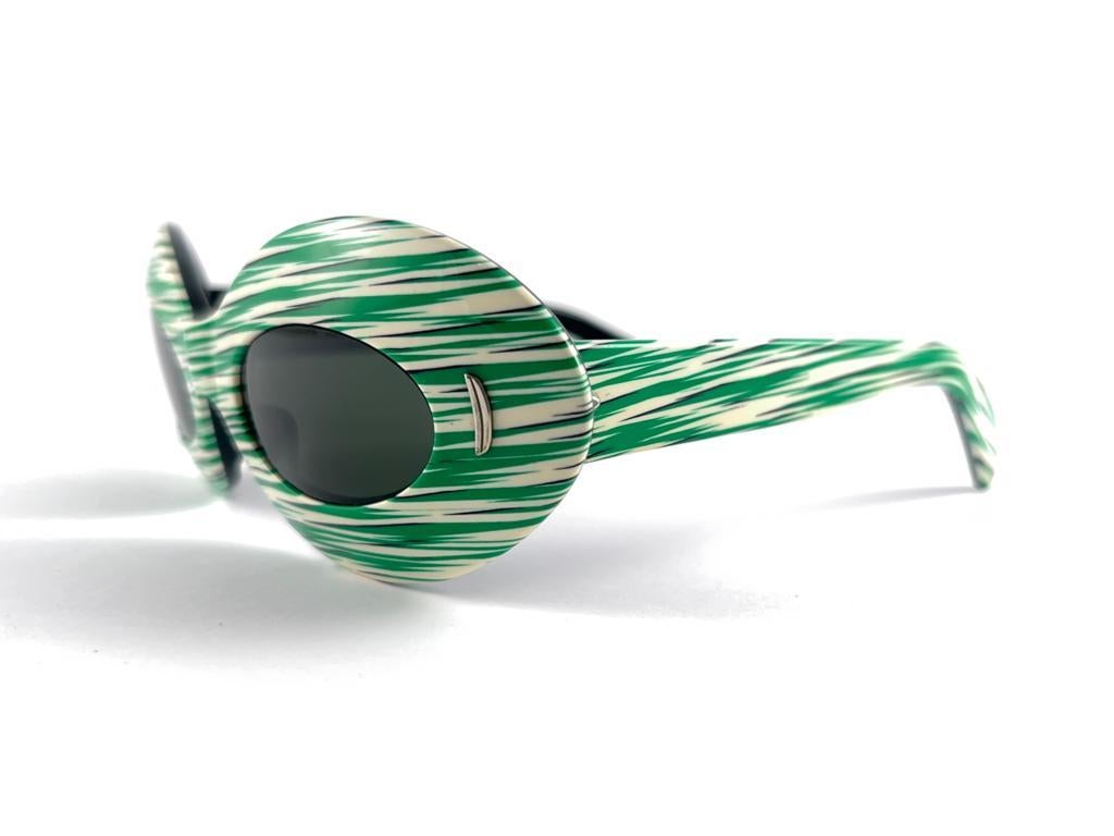 New Vintage Suntimer Victory green stripped sunglasses. Iconic frame with G15 grey lenses.

Please notice this item its almost 60 years old and show minor sign of wear due to storage.

An original and seldom piece.

FRONT : 16 CMS

LENS HEIGHT : 2.5