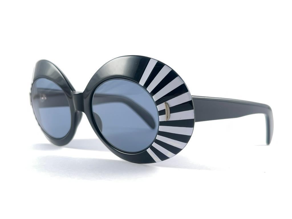 Vintage Suntimer Victory Skimo-Sonnenbrille. Ikonischer schwarz-weiß gestreifter Rahmen mit grauen G15-Gläsern.

Bitte beachten Sie dieses Element seine fast 60 Jahre alt und zeigen geringfügige Anzeichen von Verschleiß durch die Lagerung.

Ein