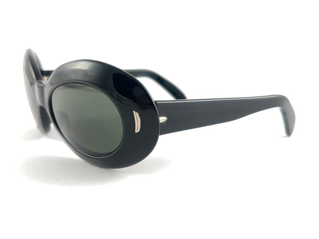New Vintage Suntimer Victory black sunglasses. Iconic frame with G15 grey lenses.

Please notice this item its almost 60 years old and may show minor sign of wear due to storage.

An original and seldom piece.

FRONT : 17 CMS

LENS HEIGHT : 3.8