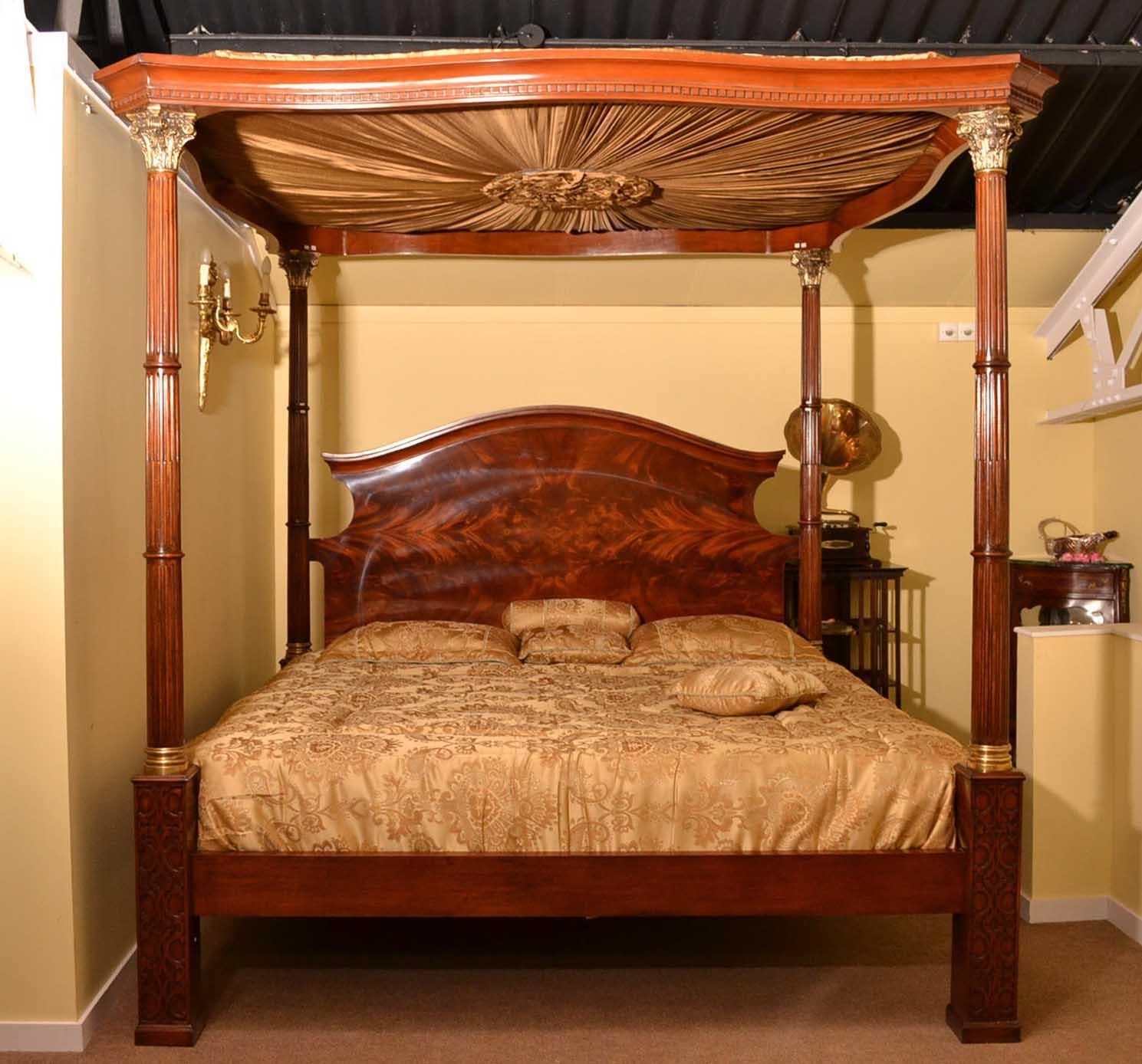This is an exquisite vintage Four Poster Bed with silk canopy dating from the late 20th Century.

It has a beautiful flame mahogany headboard and four wonderful reeded columns which are surmounted with ormolu Capitelli.

A lot of intricate