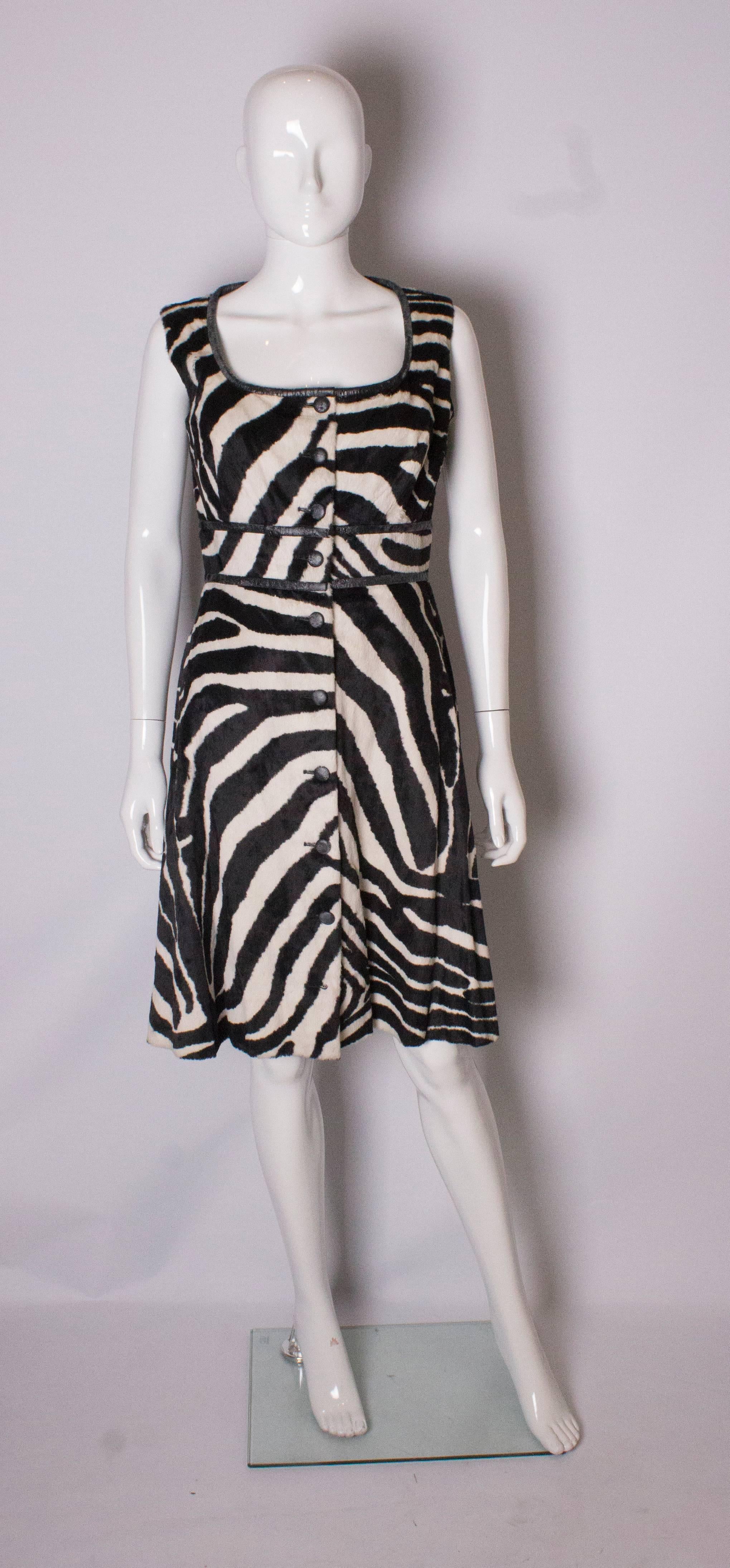 A fun vintage dress by Susan Small. In an animal print , the dress has a round neckline, is fully lined and has a button through front.