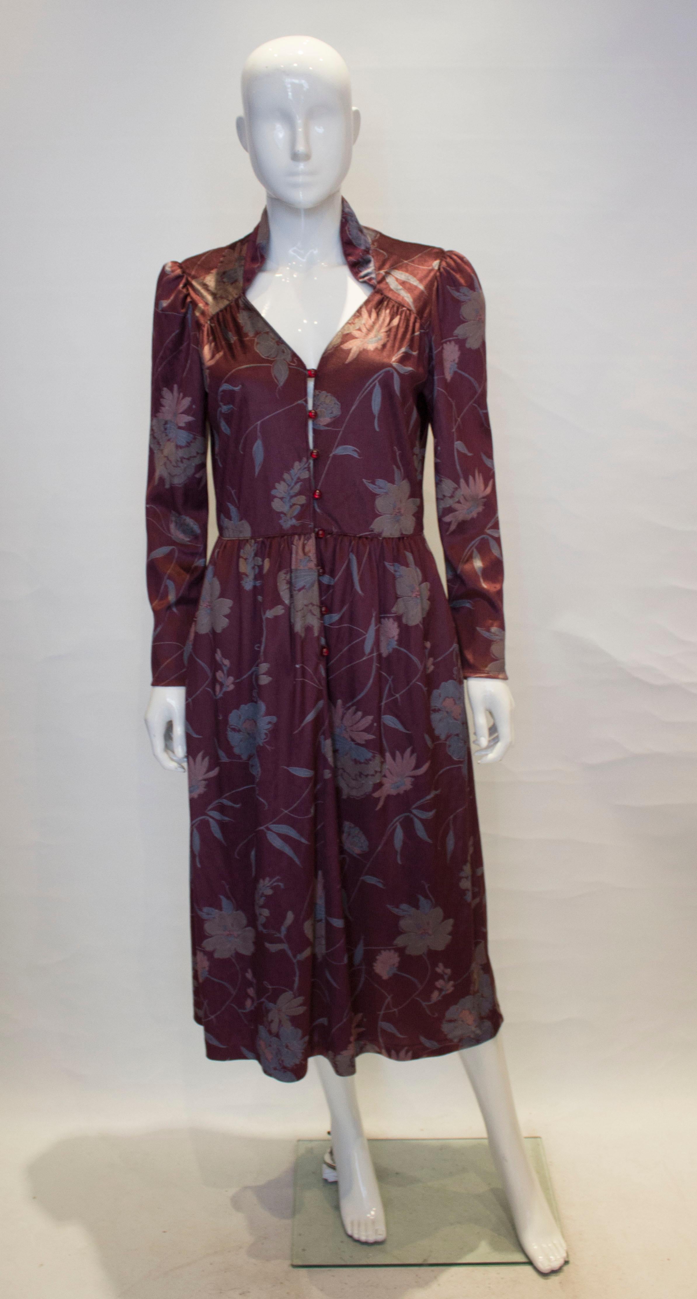 A great vintage dress by Susan Small of London. The dress is in a dusty pink floral print and has a stand up collar and sweetheart neckline. It has gathering at the waist, and the skirt area is lined with a pocket on either side.