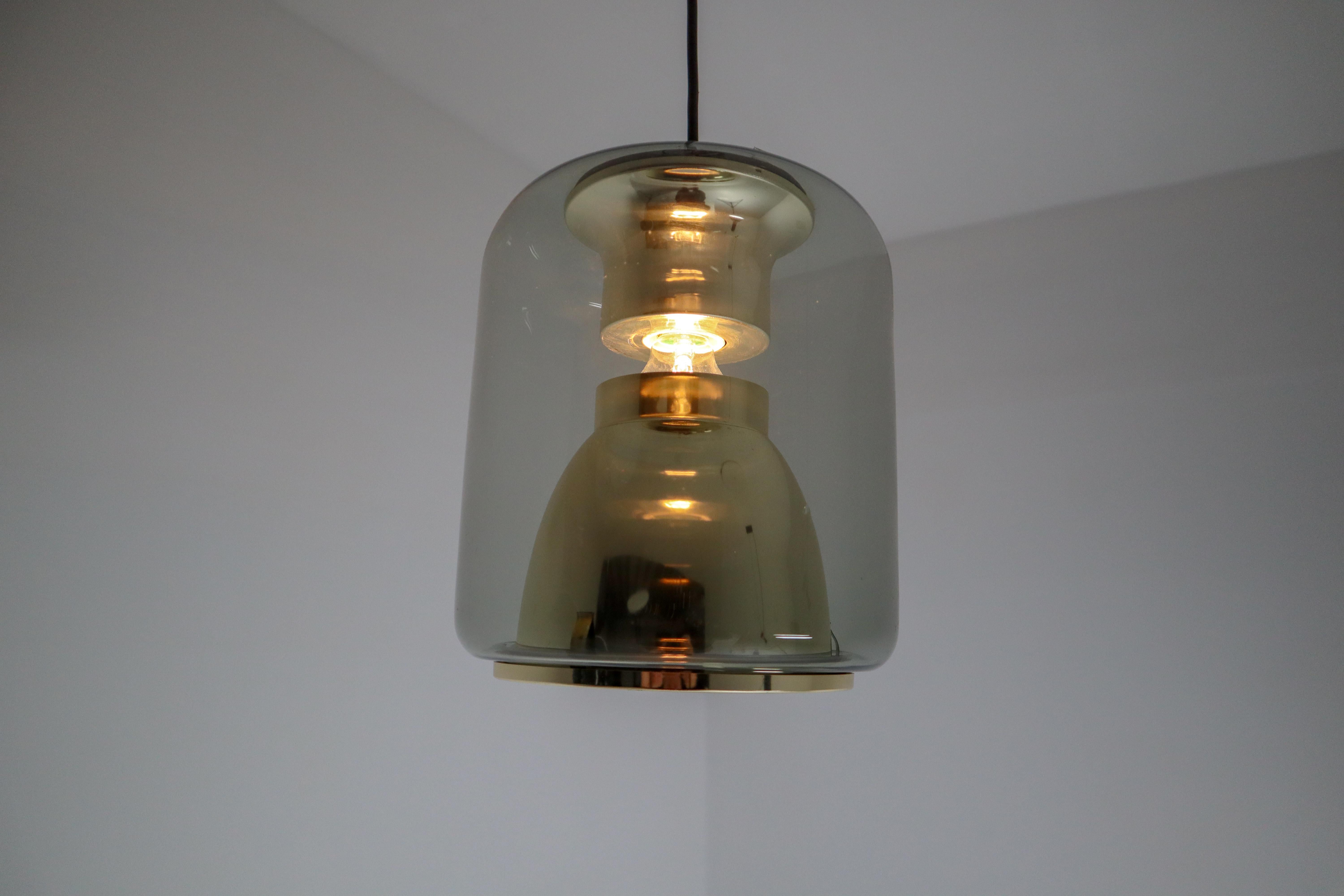 Vintage suspension lamp in smoked glass with golden details. Produced by ERCO, Germany, 1970s. Great space design for pleasant glare-free light downwards and to the sides. The frame inside is made of brass anodised aluminum. These lights will