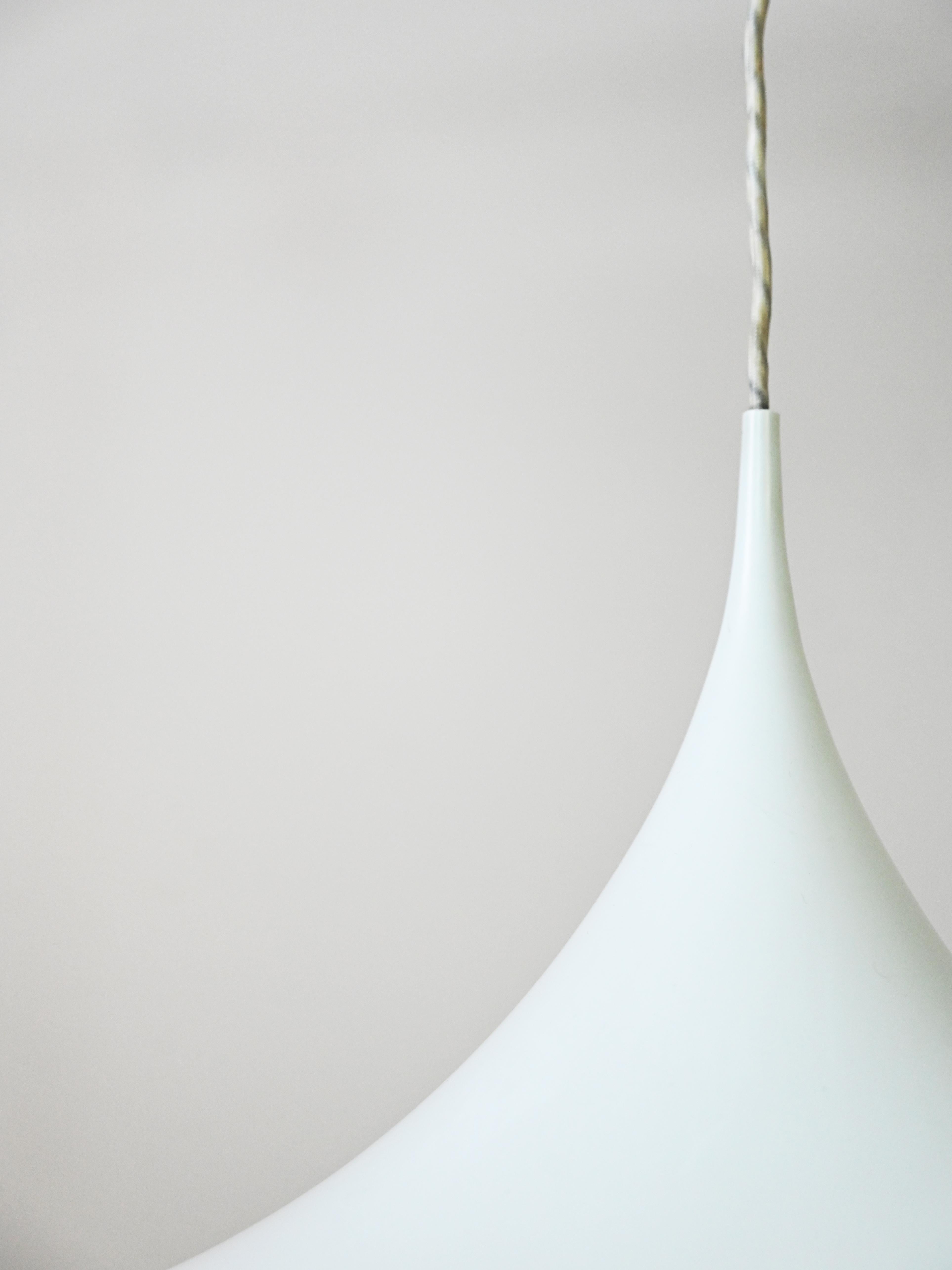 An icon of Scandinavian design, Semi is the result of a collaboration between two renowned Danish designers: Torsten Thorup and Claus Bonderup.

Made from matte white enameled metal, it exudes an elegant and refined aesthetic. The lampshade's shape