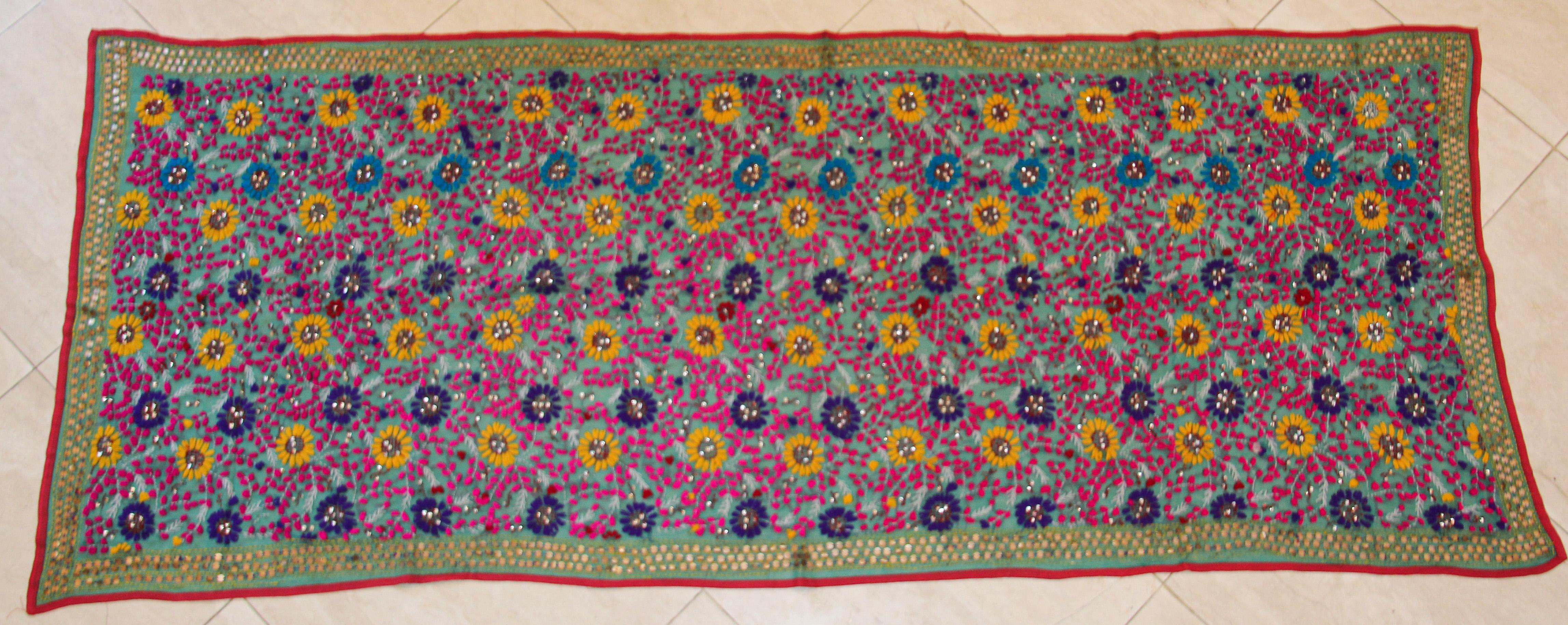 Vintage Suzani Embroidery in teal background with yellow, pink turquoise and adorned with sequins.
