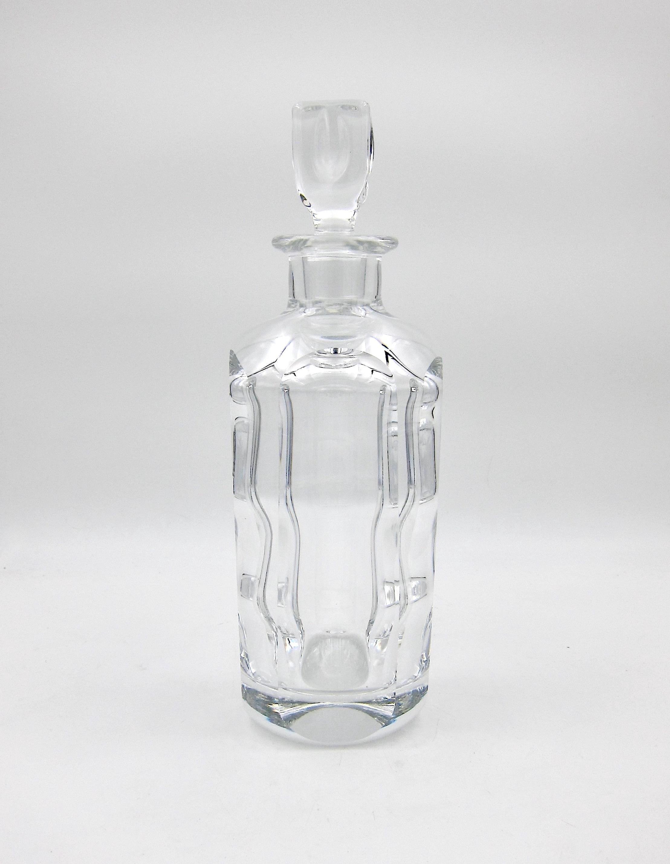 A vintage Scandinavian cut crystal decanter designed by Sven Palmqvist (Palmquist) for Orrefors of Sweden. The heavy clear crystal decanter has an elegant, modern look with an original stopper resembling an ice cube and long oval facets running the