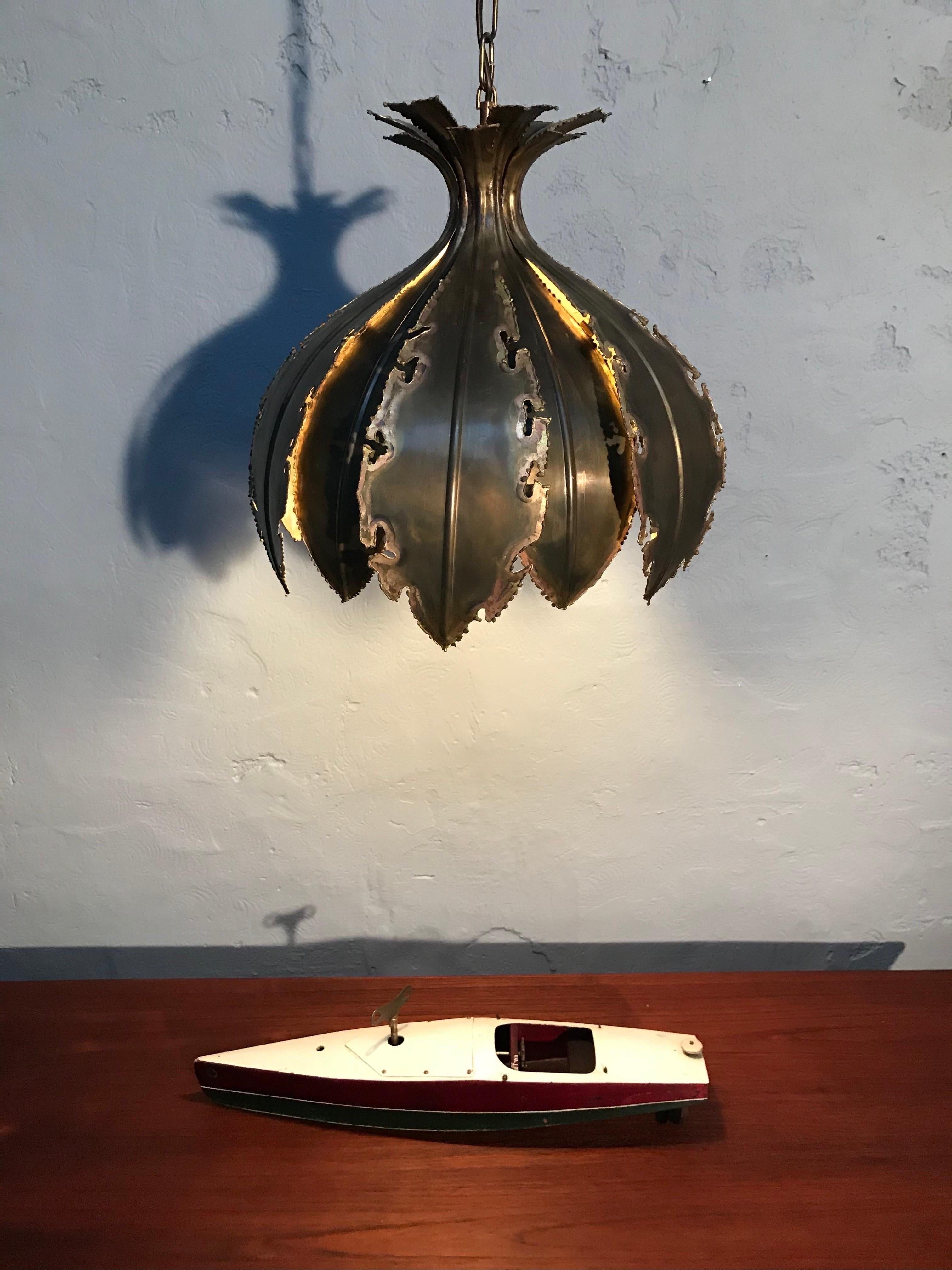 Lámpara de araña colgante vintage Svend Aage Holm Sørensen para Holm Sørensen & Co, modelo 6395.
Conocida como la cebolla, esta pieza clásica de iluminación brutalista está formada por dos capas de latón cortado con soplete.
El diseñador danés Svend
