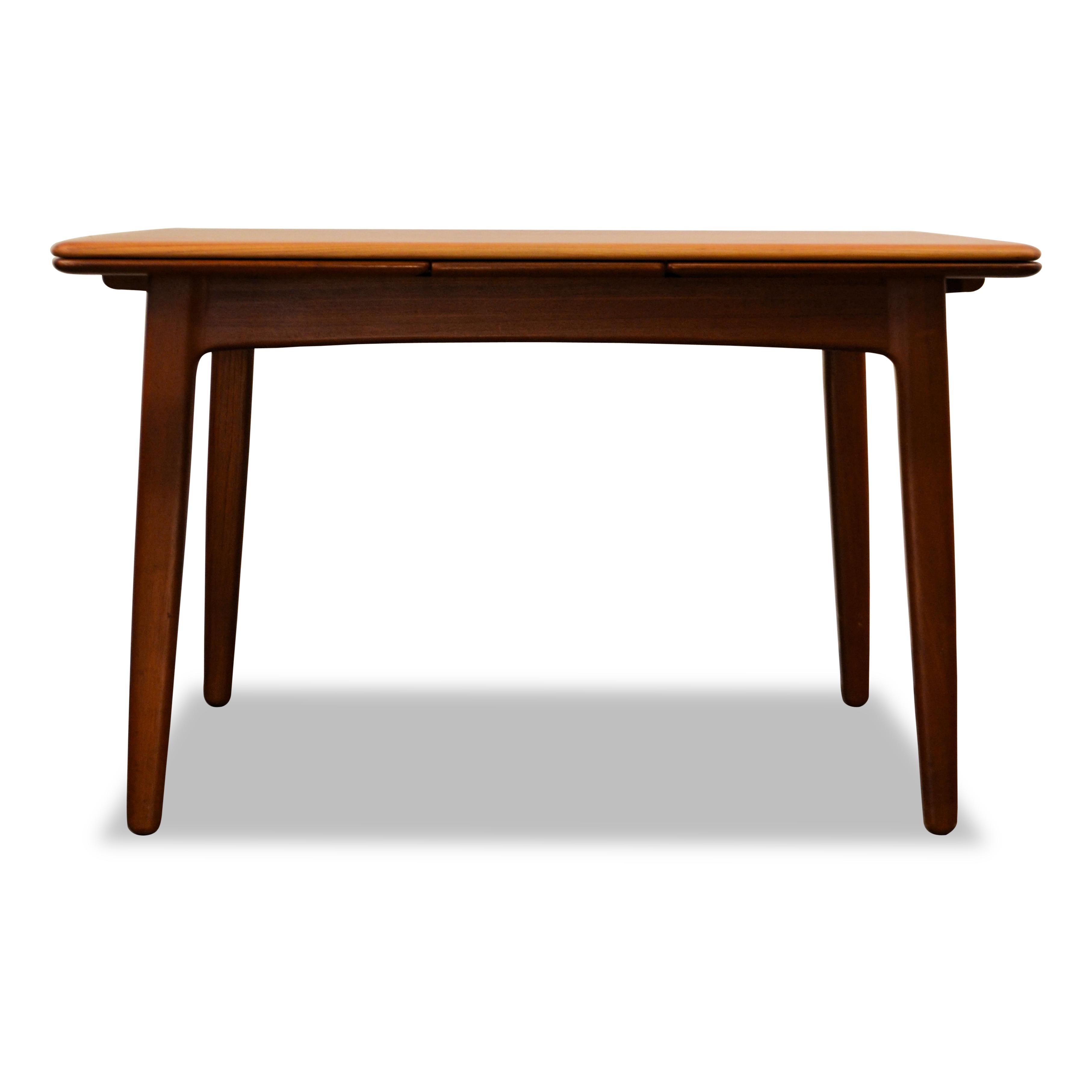 Stylish Danish Modern teak dining table designed by Svend Aage Madsen for manufacturer K. Knudsen. This “small” version easily hosts a group of 8 using the two extension pieces, which add 90 cm in length. This high quality Danish design piece will