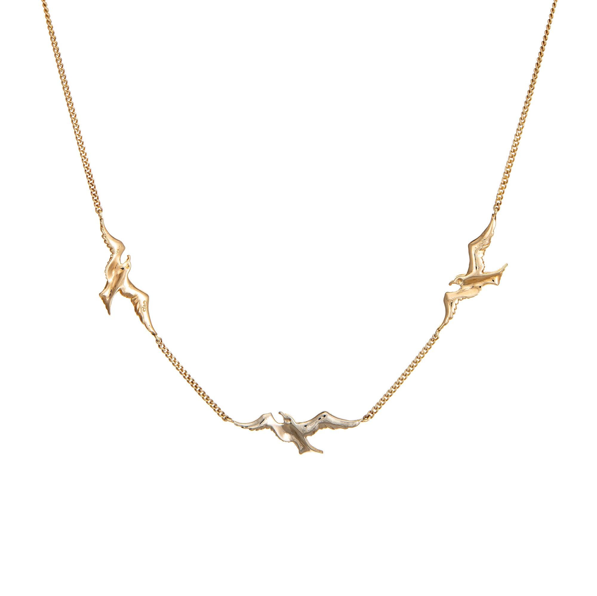 Stylish and finely detailed vintage swallow necklace crafted in 14 karat yellow & white gold (circa 1980s to 1990s).

Three swallows in full flight are embedded into the chain (two in yellow gold and one center set swallow in white gold). The