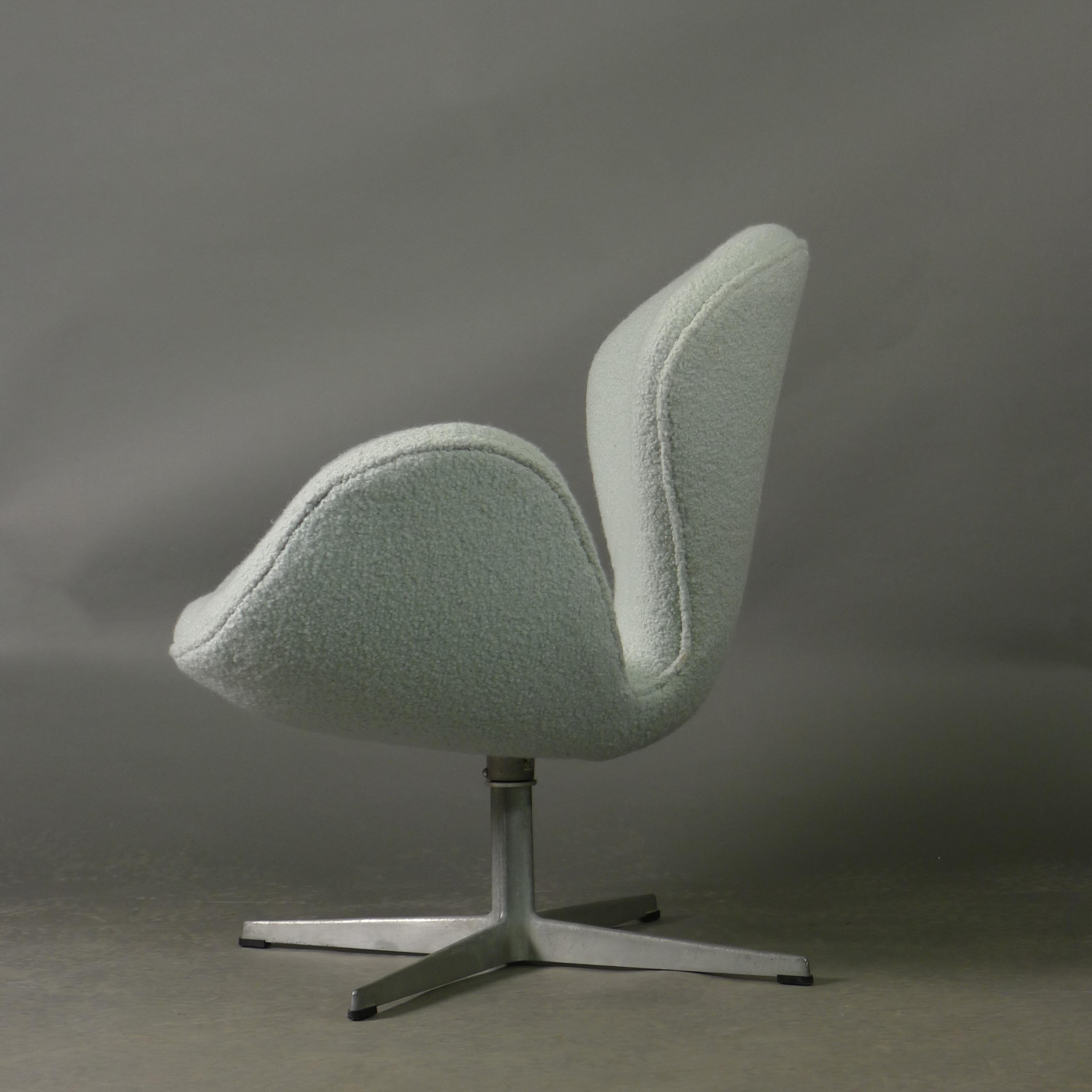 Deux chaises Swan vintage conçues par Arne Jacobsen et fabriquées par Fritz Hansen à Copenhague, Danemark.

Les chaises ont été nouvellement recouvertes d'un tissu bouclé en laine de haute qualité, bleu glacier, par Rose Uniacke. La base porte le
