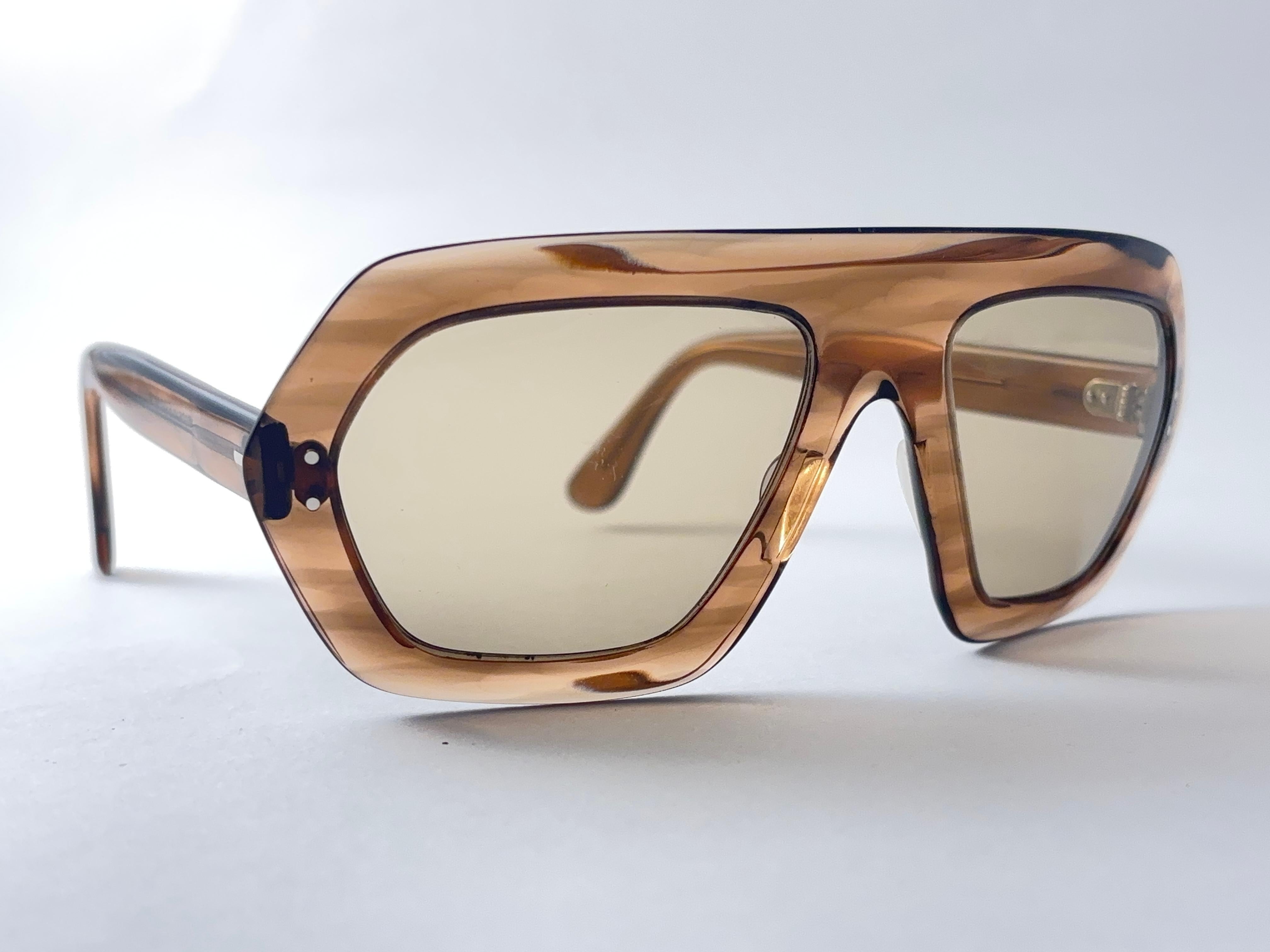 Gafas de sol vintage súper raras Toffee Swank con un par de lentes marrón claro.
Fabricado en Francia.

Este artículo muestra signos menores de desgaste debido al almacenamiento.

Medidas 

Frente : 15 cm 
Altura de la lente : 4,5 Cms
Anchura de la