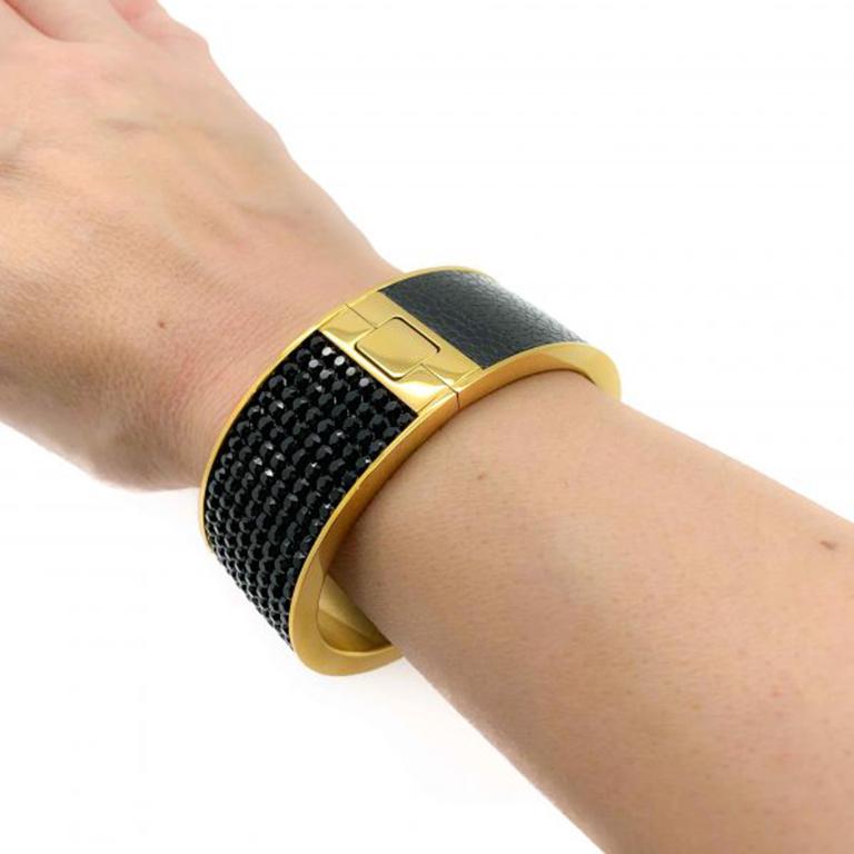 A substantial and super stylish Gold and Black Vintage Swarovski Bangle. One of the best examples of a Swarovski cuff. Bold and beautiful. Featuring stunning pave set black crystals on one half and leather on the other upon a high quality gold
