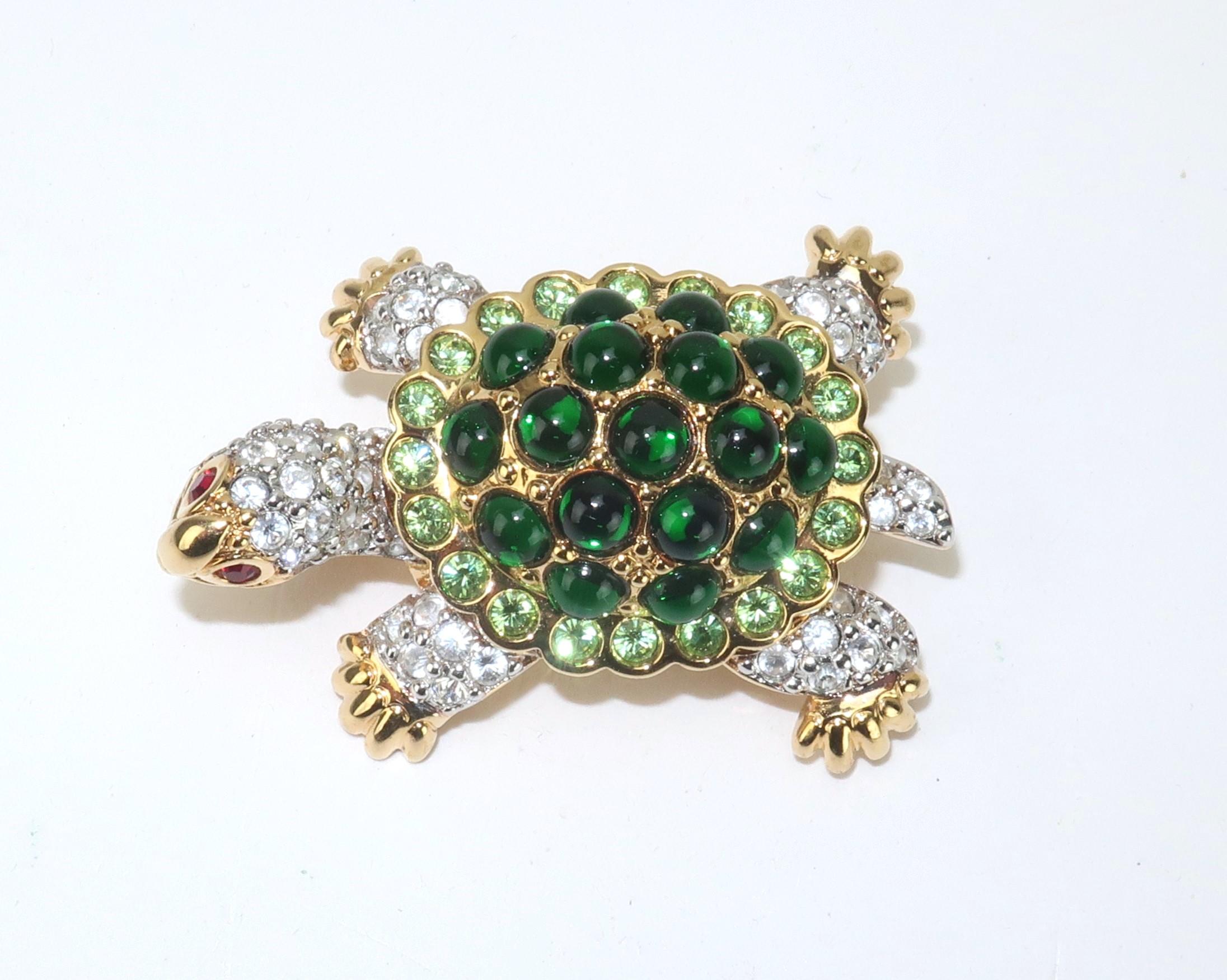An adorable Swarovski turtle brooch loaded with personality and adorned with brilliant crystals, lime green rhinestones, green glass cabochons and ruby red crystal eyes. Set in a gold tone metal and outfitted with a straight pin and safety catch.