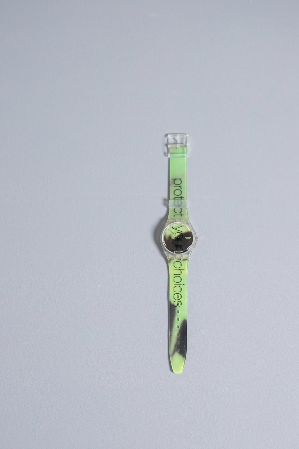 Vintage Swatch with a minimal design and acid green color, along the entire strap there is the writing 