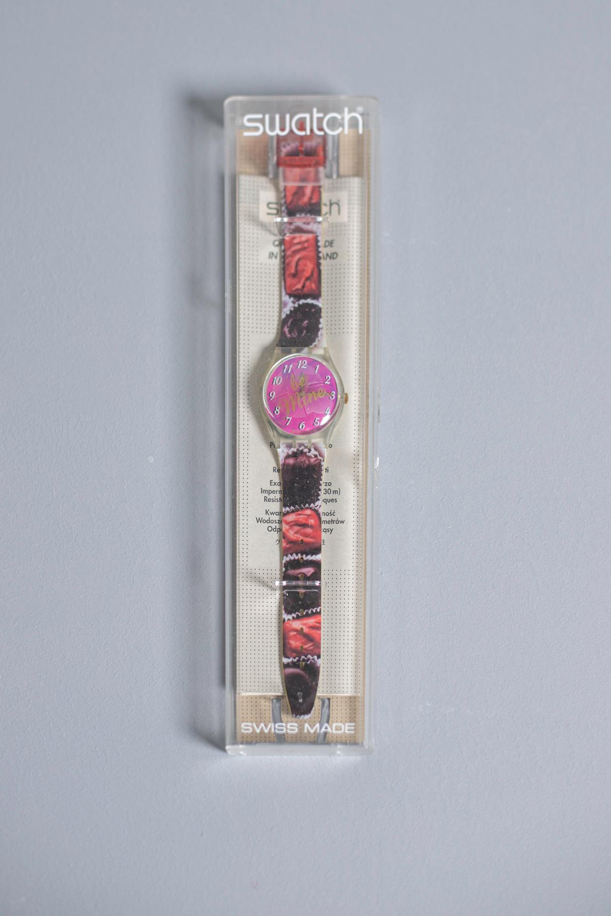 Historical collection Swatch Be Mine year 1999. This is the vintage Swatch collection. The watch has greedy chocolates on the strap, a pink dial and the words 