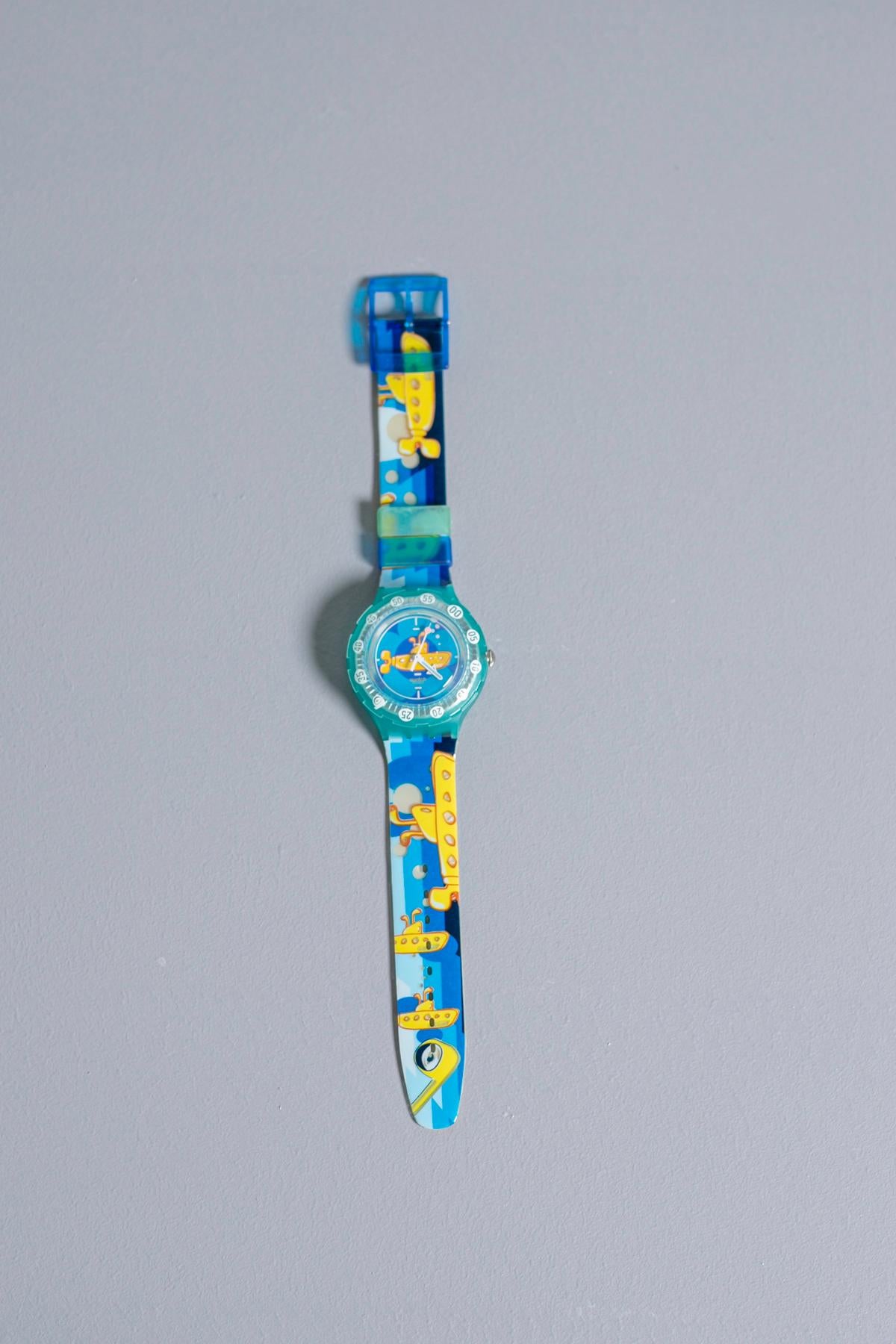 Beautiful vintage Swatch dedicated to fans of the legendary Abbey Road band: the Beatles. The iconic yellow submarine is drawn along the strap, making this collector's item even more special is the packaging: an inflatable yellow submarine.

Case
