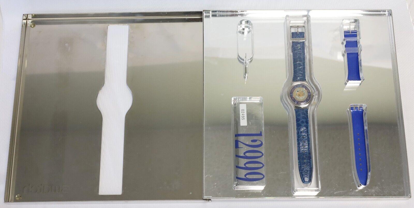 Este es un raro reloj automático Swatch Tresor Magique Platinum vintage, un lanzamiento destacado de la serie de coleccionistas de Swatch de 1993. Presenta una caja de platino y una esfera esqueletizada con un diseño de números romanos celestes. El