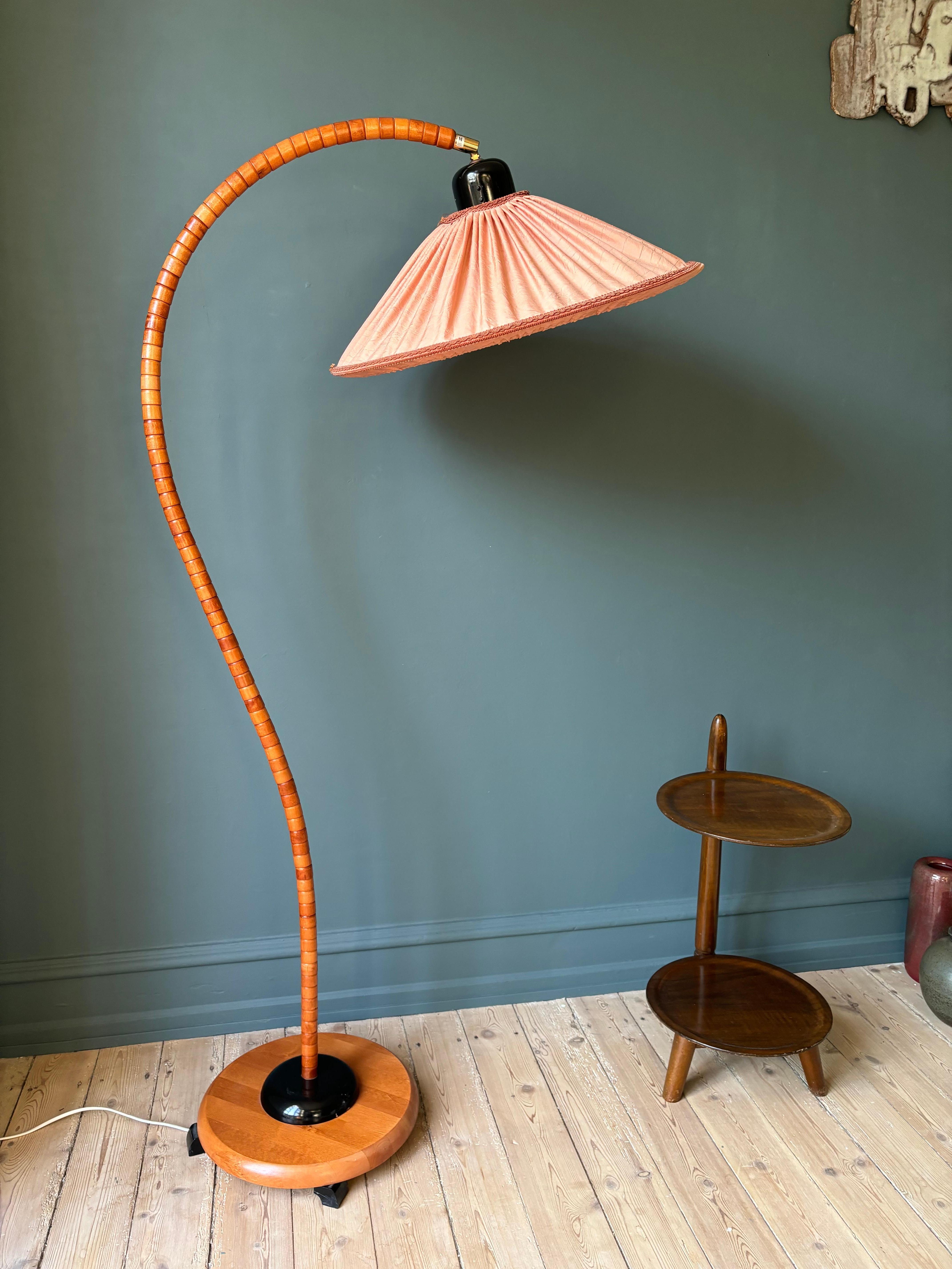Lampadaire sculptural de forme organique de style art déco / art nouveau conçu et produit par le suédois Markslöjd dans les années 1960. Des étages de pièces en bois de hêtre massif laqué clair créent une grande forme en col de cygne placée sur une