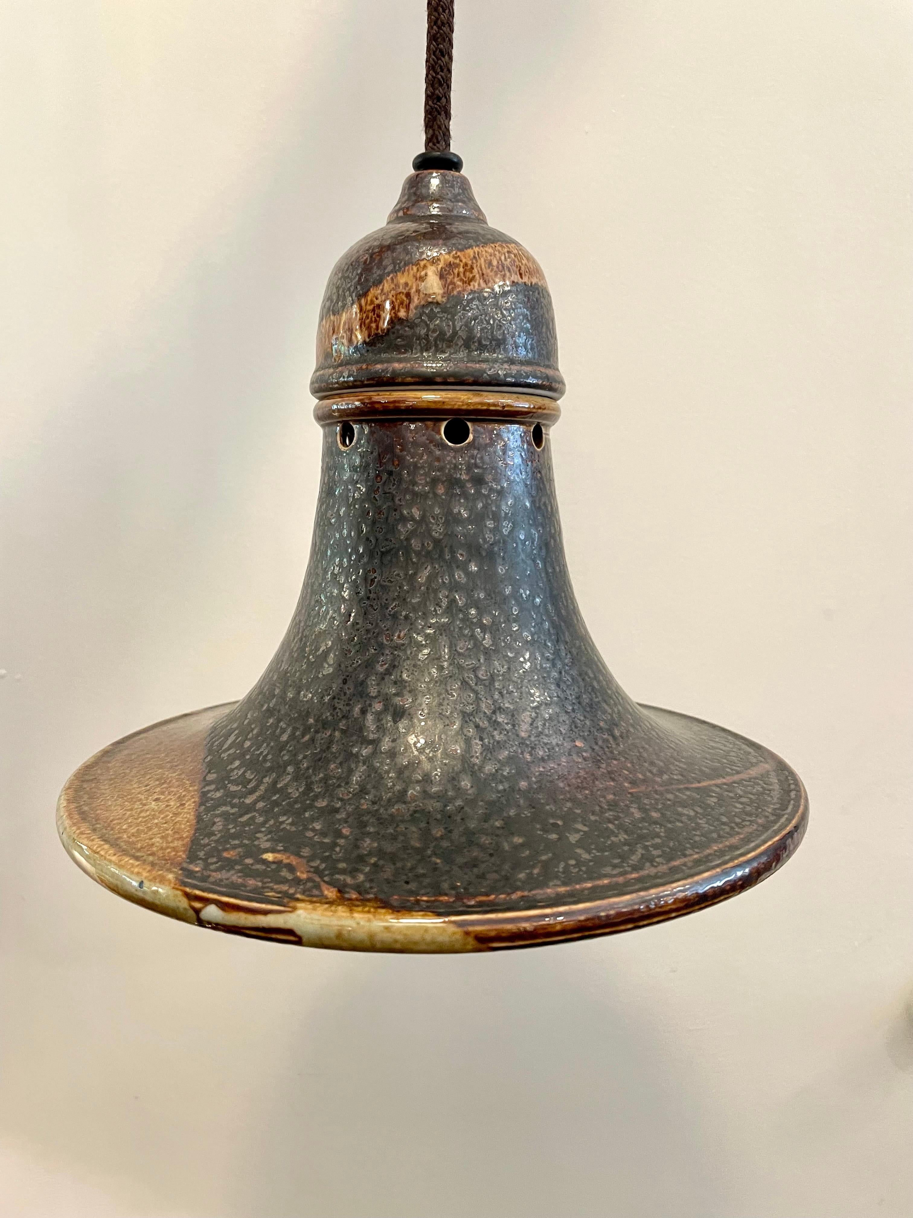 Un ensemble de SIX lampes suspendues en céramique scandinave de couleur terre, en forme de cloche, datant du milieu du siècle dernier.  Ils sont vendus individuellement.  Le baldaquin est en céramique d'origine assortie et ils fournissent un