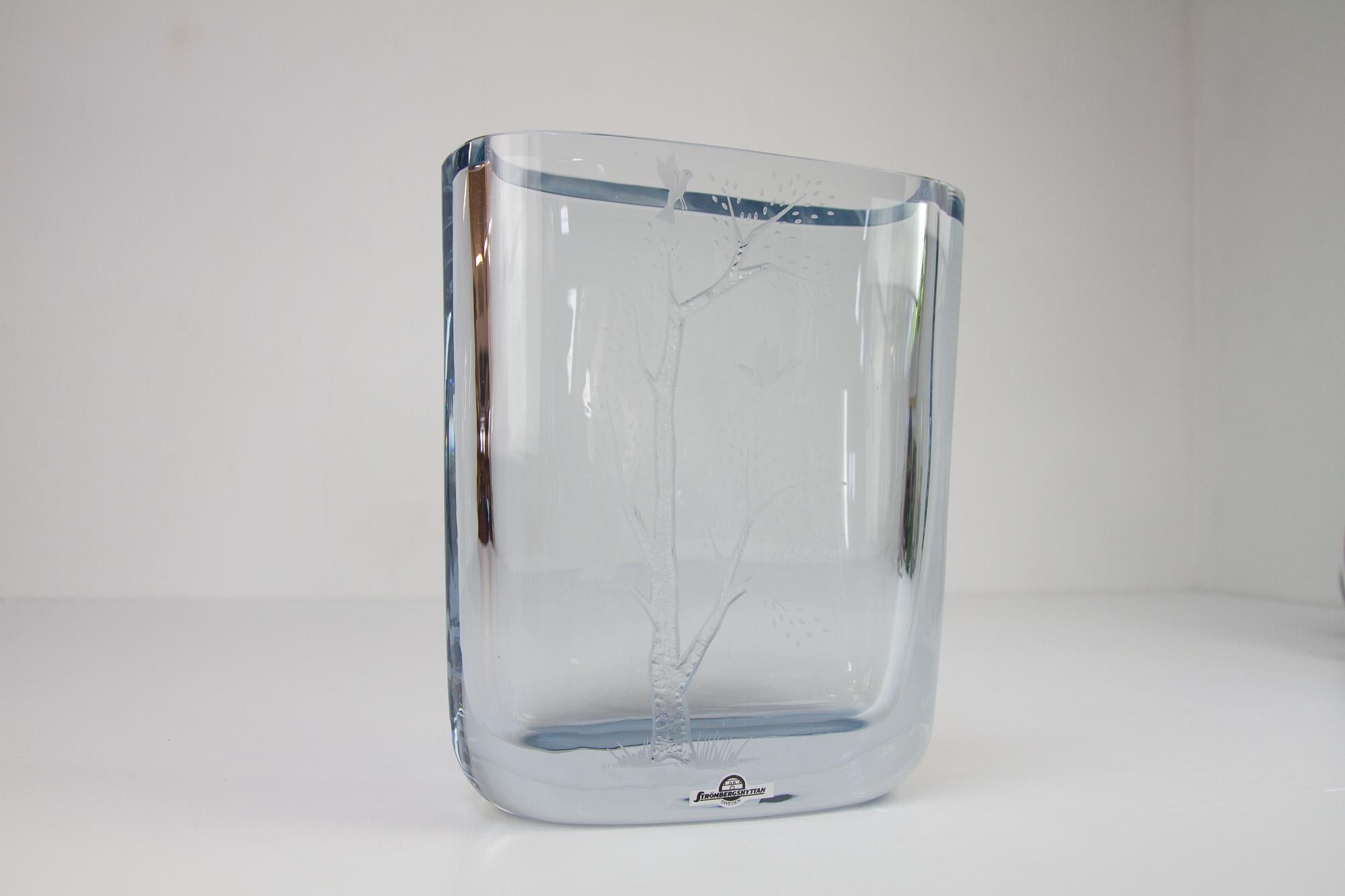 Vintage Swedish Blue Crystal Vase by Asta Strömberg for Strömbergshyttan, 1950. 
Large and heavy glass art in thick silver-blue tinted glass with etched motif of a tree with birds.
Excellent vintage condition with intact sticker. Signed underneath