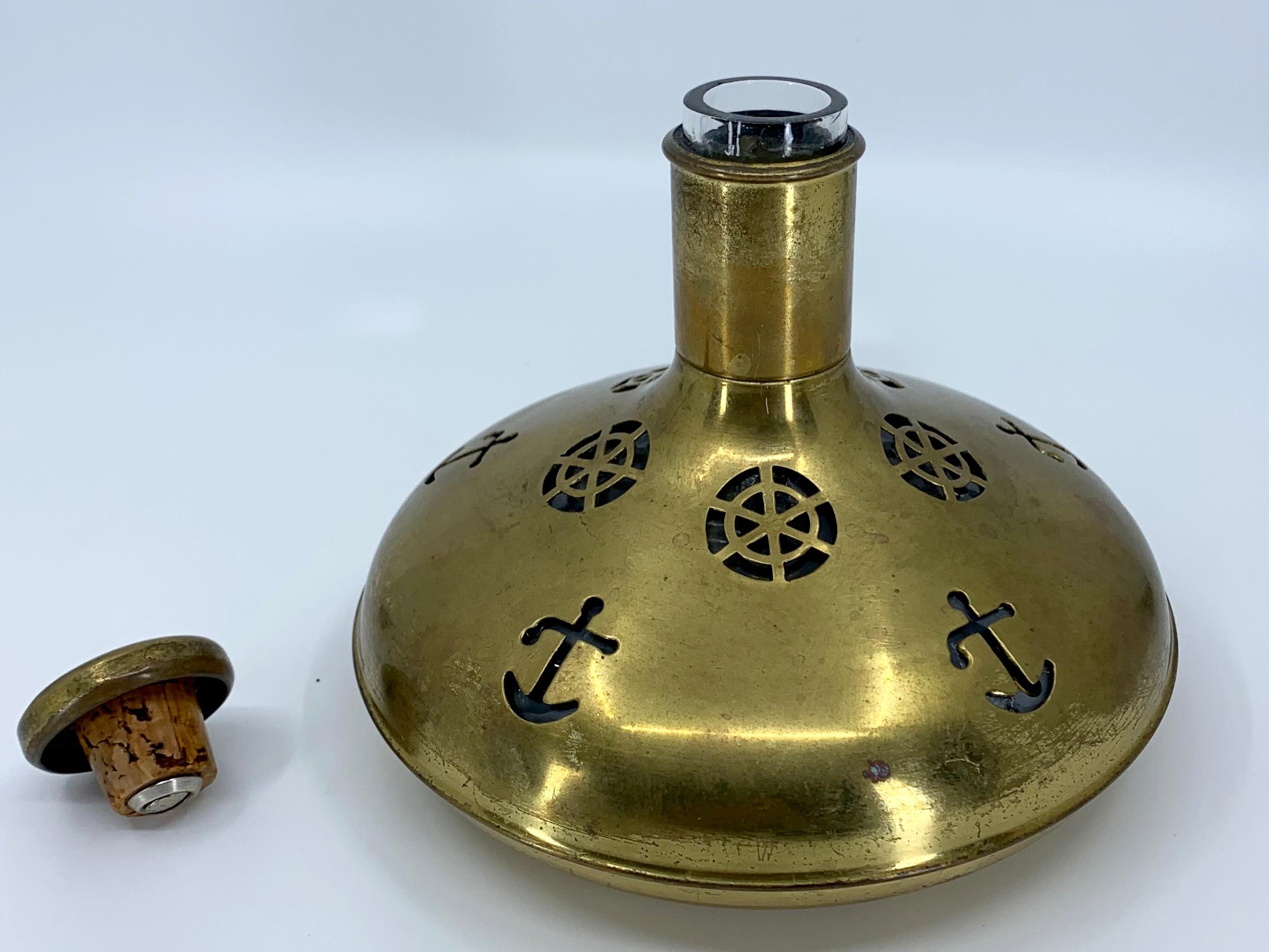 Vintage Swedish brass nautical flask. Midcentury pierced brass encased glass bottle and stopper with ship’s wheel and anchor designs; perfect for the captain’s table and every boating picnic. Sweeden, mid-20th century.
Dimensions: 7