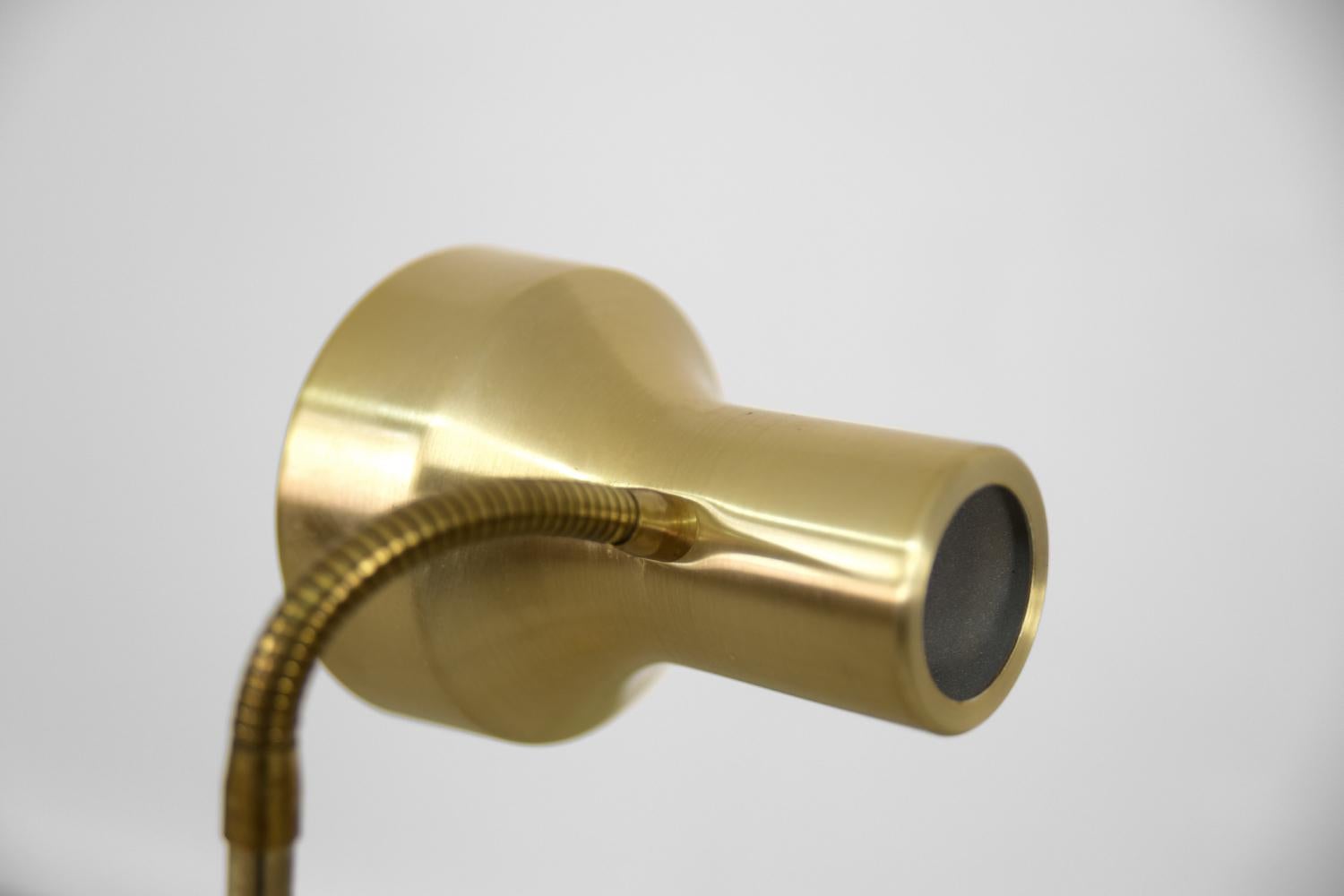 This gold floor lamp was manufactured by the Swedish manufacturer Montör during the 1970s. Model number 0145. It is made of brushed brass with truly classic look. It has a movable spotlight due to get throw the light in any direction. The lampshade