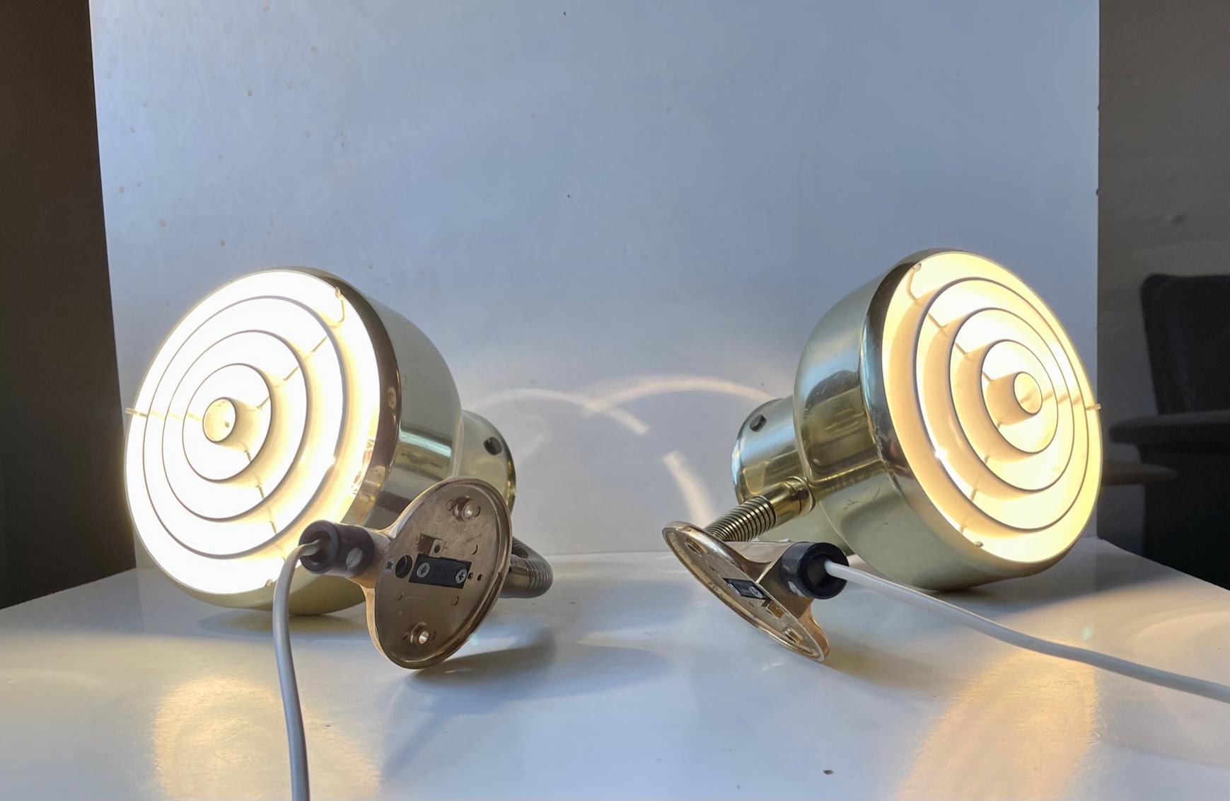 A pair of period wall lights in solid brass. This model is called Bumling and it was designed by Anders Pehrson during the 1960s and manufactured by Atelje Lyktan in Åhus, Sweden during the 1970s. Due to their flexible goose-neck they are fully