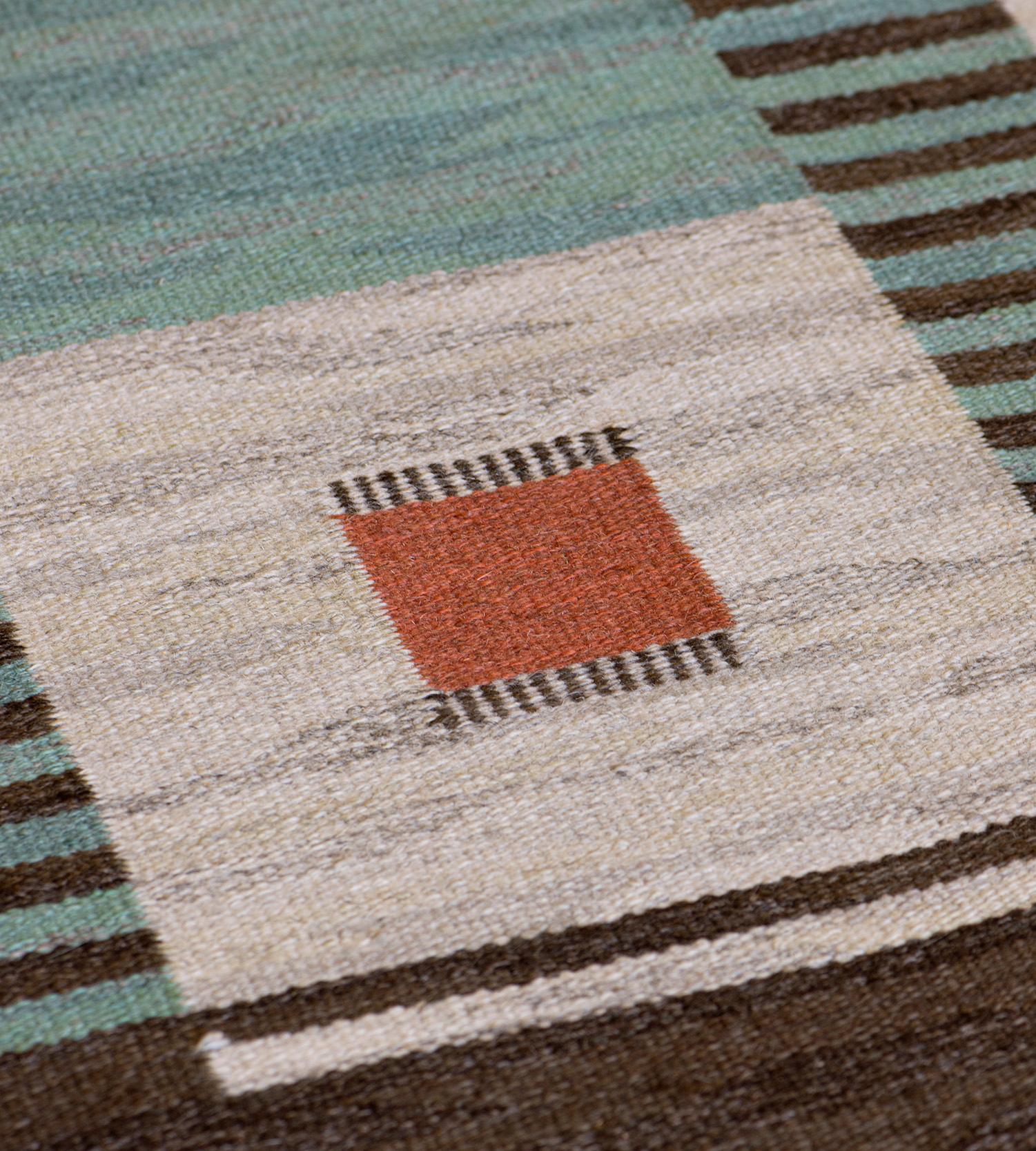 This traditional handwoven Swedish Deco rug has an overall field of broad alternating turquoise and sapphire rows overlaid by checkered ivory cells, each enclosing ruby panels, separated by delicate chocolate brown striped columns. Signed TPB for