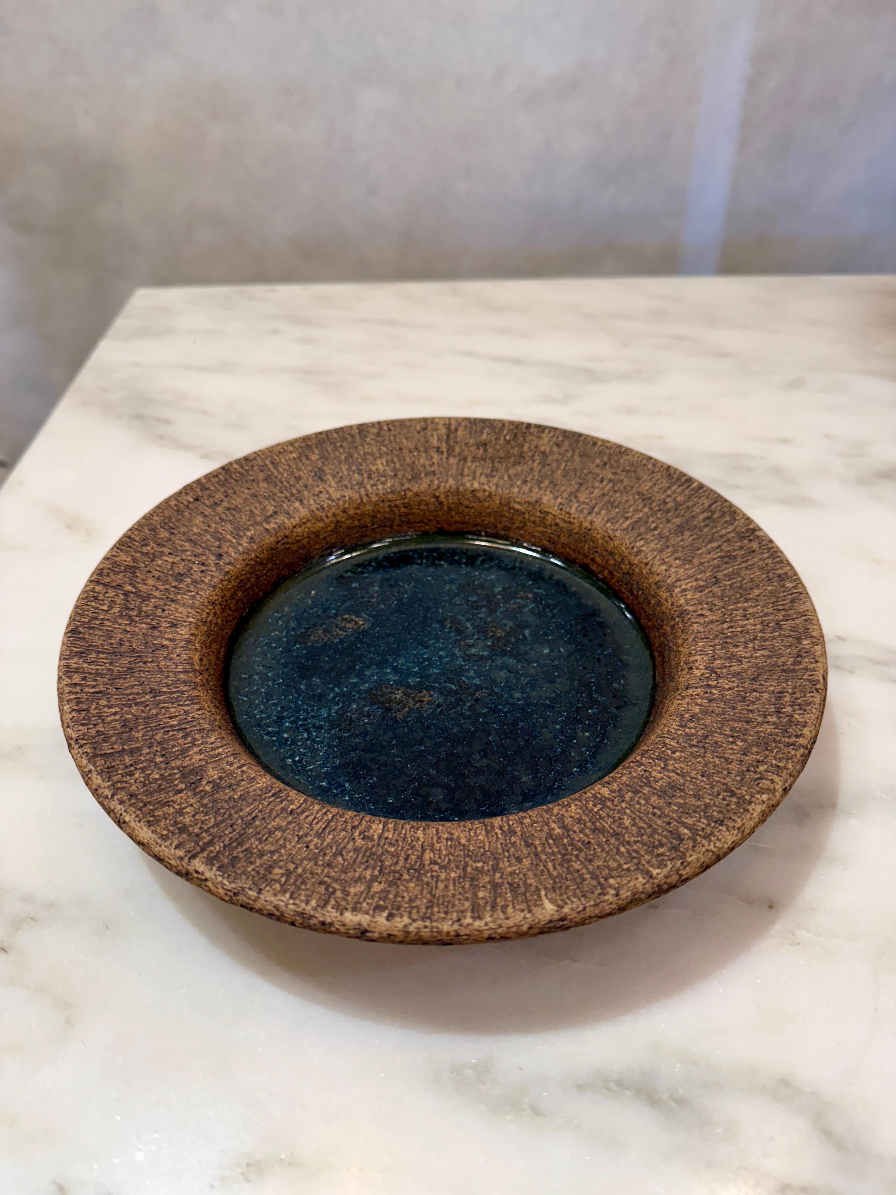 Questa ciotola di terracotta presenta una finitura a corteccia d'albero sul bordo esterno e una bellissima tonalità marrone scuro.  Firmato sul lato inferiore.
NOTA: diametro di 6 pollici fino all'interno della ciotola smaltata.