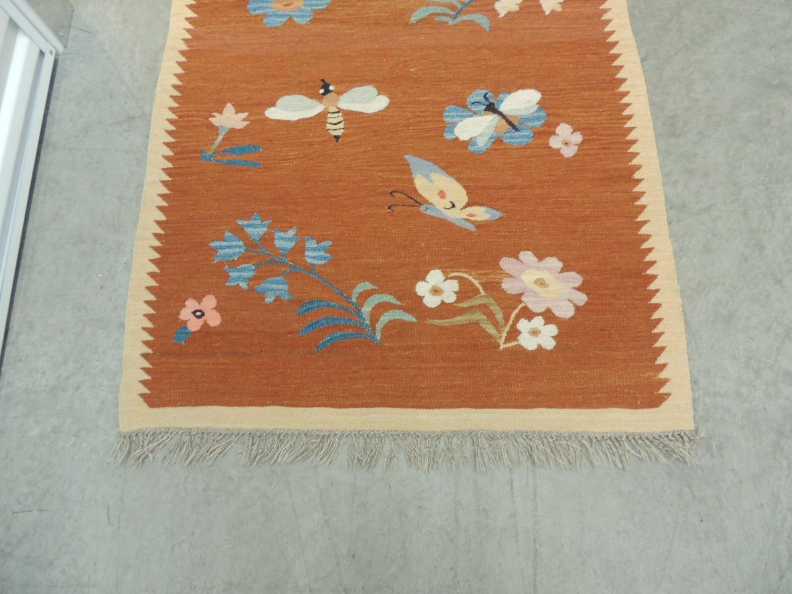 Vintage Swedish flat-weave floral runner with hand knotted fringes.
Rik Rak pattern border, rust color field depicting butterflies, bees, daisies, tulips, roses,
Jasmin, dragon flies, poppies.
In shades of rust, tan, blue, pink, mauve, red,