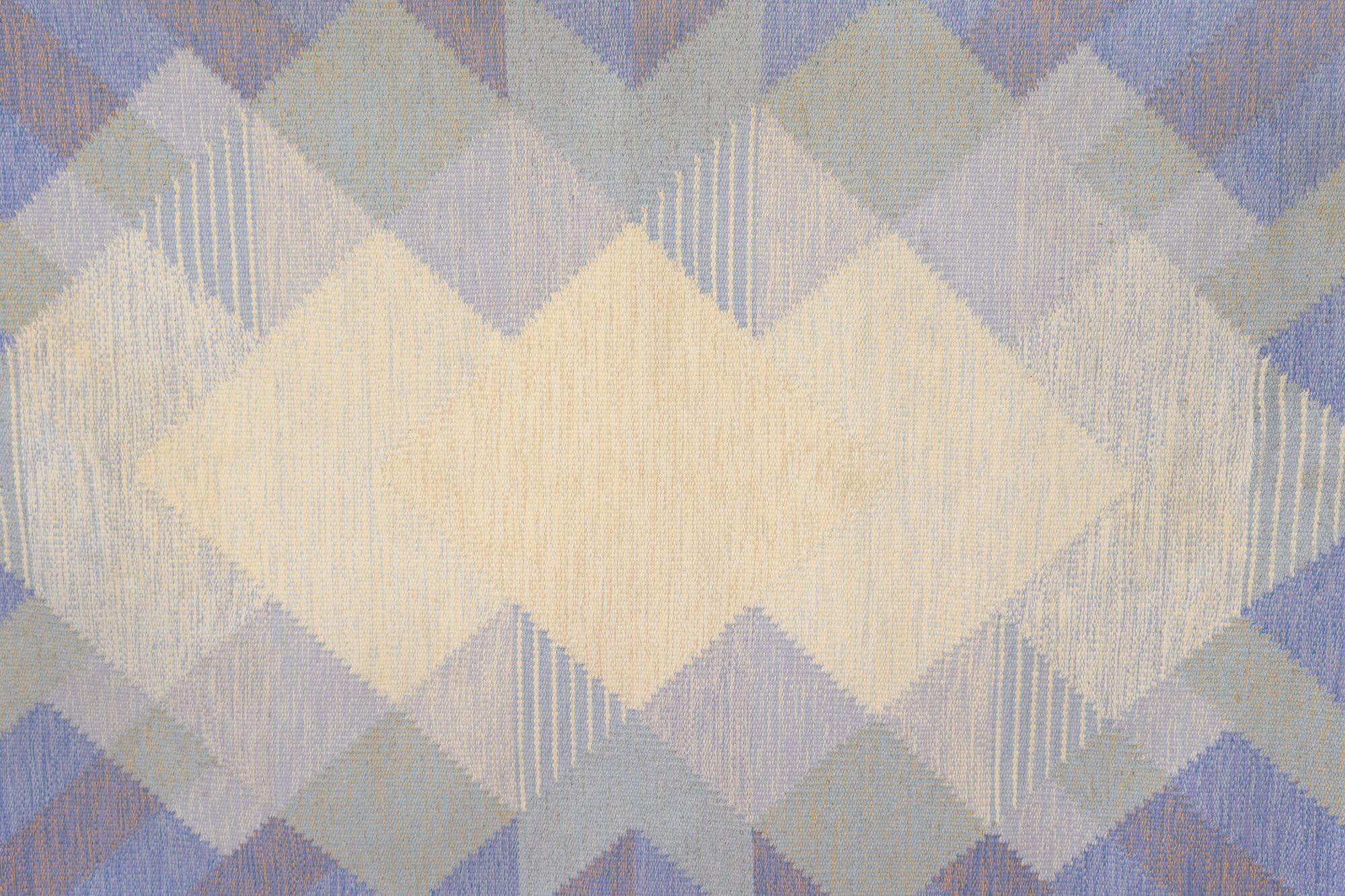 Grand kilim suédois du milieu du siècle par Anna Johanna Ångström. Dans des tons bleus et crème, avec un motif répétitif en forme de diamant. Nettoyé par des professionnels. Circa 1960. Tous nos tapis anciens font l'objet d'un nettoyage