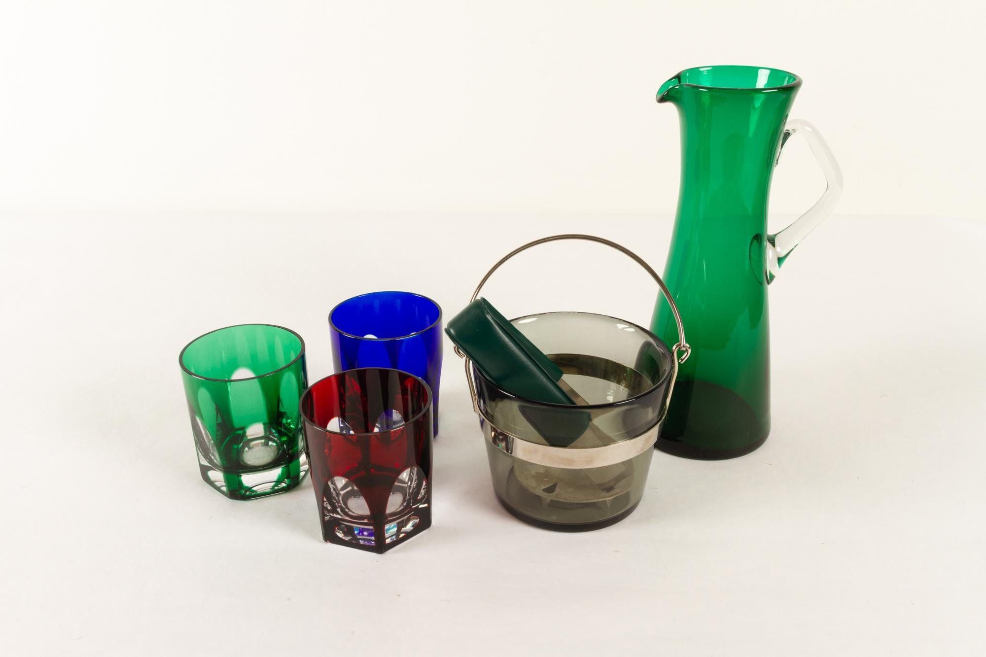 Vintage Swedish glassware 1960s Set 5
Mid-century modern barware. A stylish and colorful addition to the bar cart or bar cabinet.
This set consists of:
1 Pitcher in green glass, height 24.5 cm
3 Whiskey glasses, red, blue and green, height 9