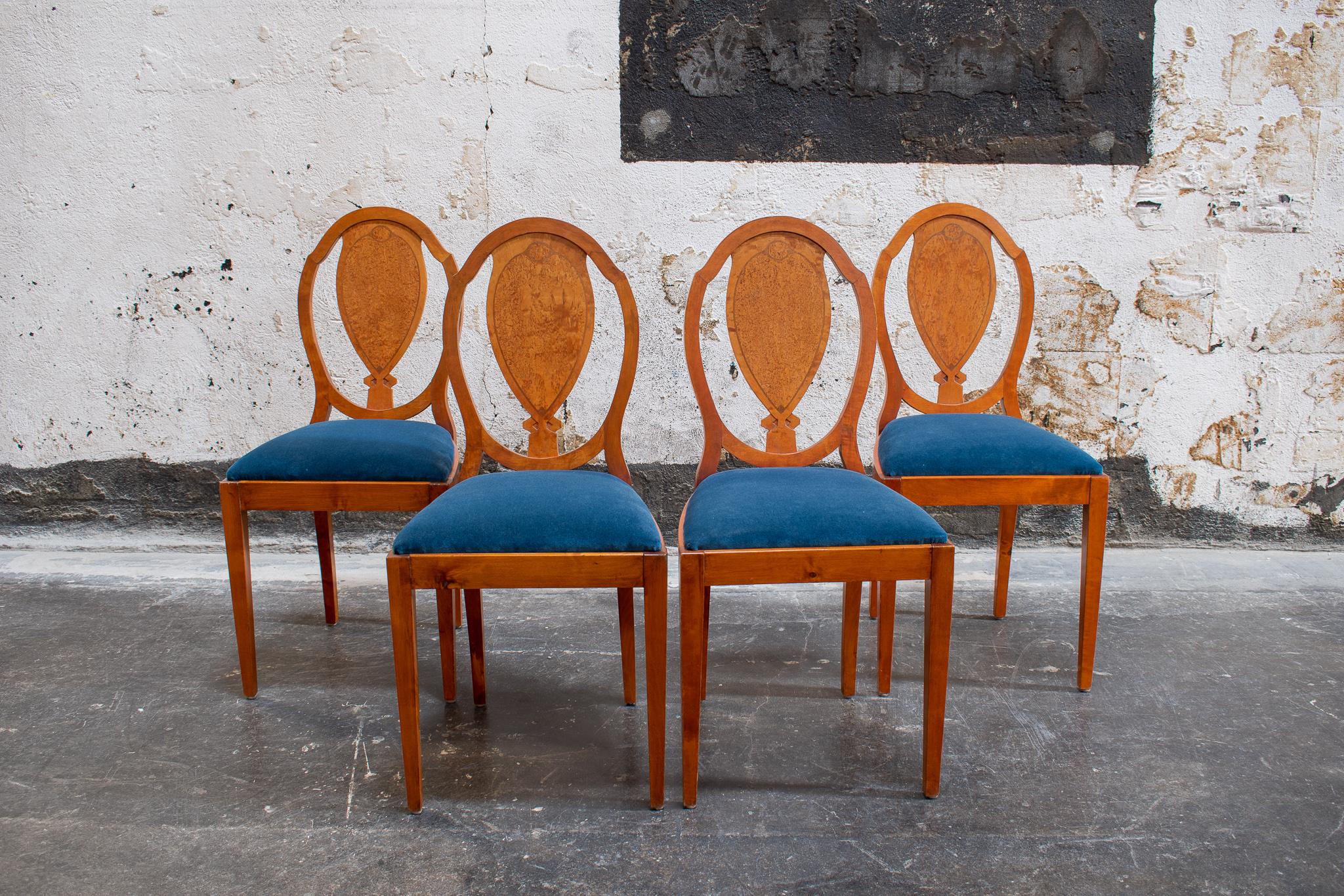 Solid golden birch chairs with rare Masurbjork, sometimes also referred to as Karelian birch or Burl Birch, inlaid shield back rests. This is a very special dining chair set, in wonderful condition considering their age. The vintage royal blue
