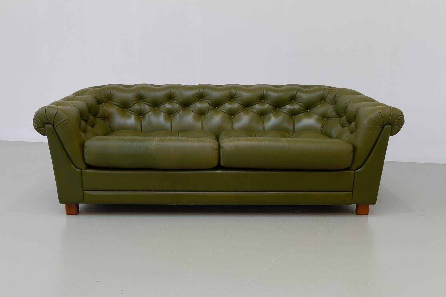 Sofa Chesterfield suédois vintage en cuir vert, années 1970

Magnifique canapé deux places et demie de style Chesterfield en cuir vert olive patiné. Fabriqué en Suède dans les années 1970.
Cuir souple et résistant de haute qualité, très
