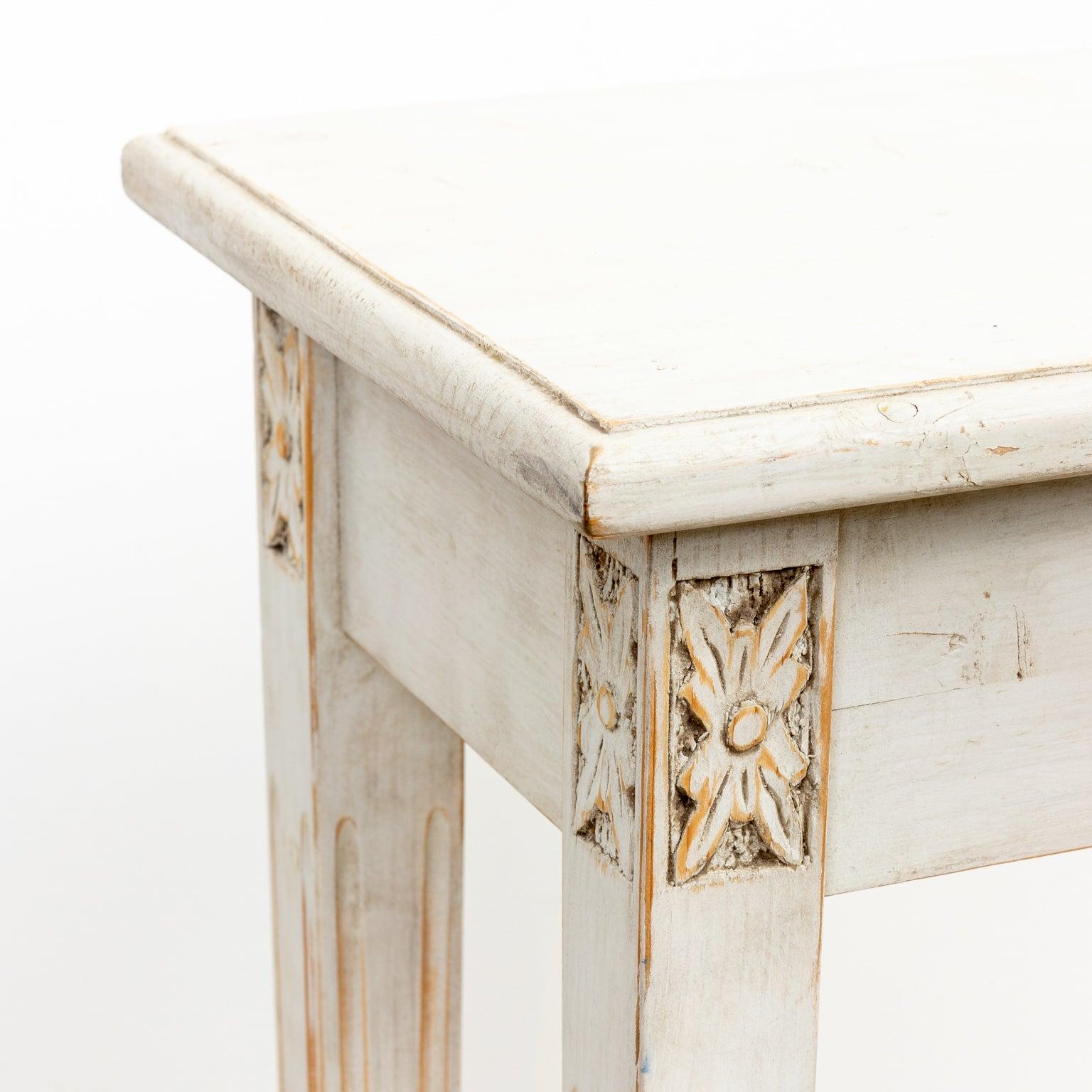 A vintage Gustavian style/Swedish square occasional table with lovely carved wood accents painted in a chalky milk paint. Wear consistent with age.