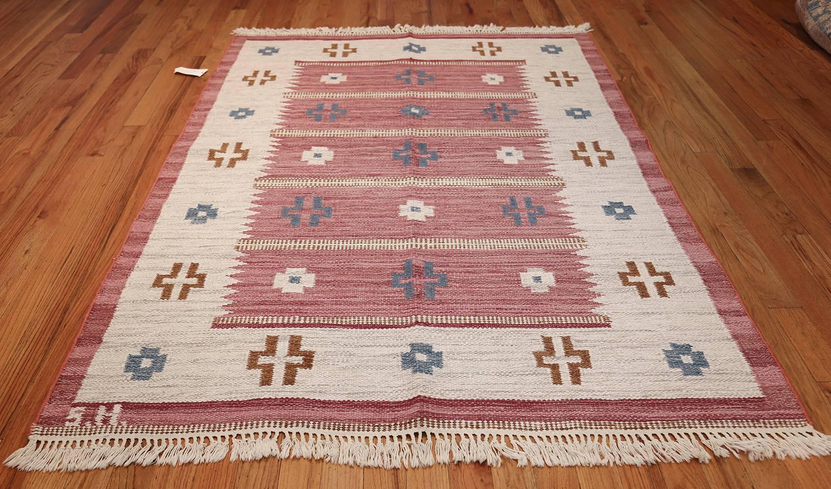 Vintage Swedish Kilim by Svensk Hemslojd, Origin: Sweden, circa mid-20th century. Size: 5 ft 5 in x 8 ft (1.65 m x 2.44 m)

A comely pallet of red, ivory, and blue, this charming Swedish kilim beautifully espouses some of the finer qualities of