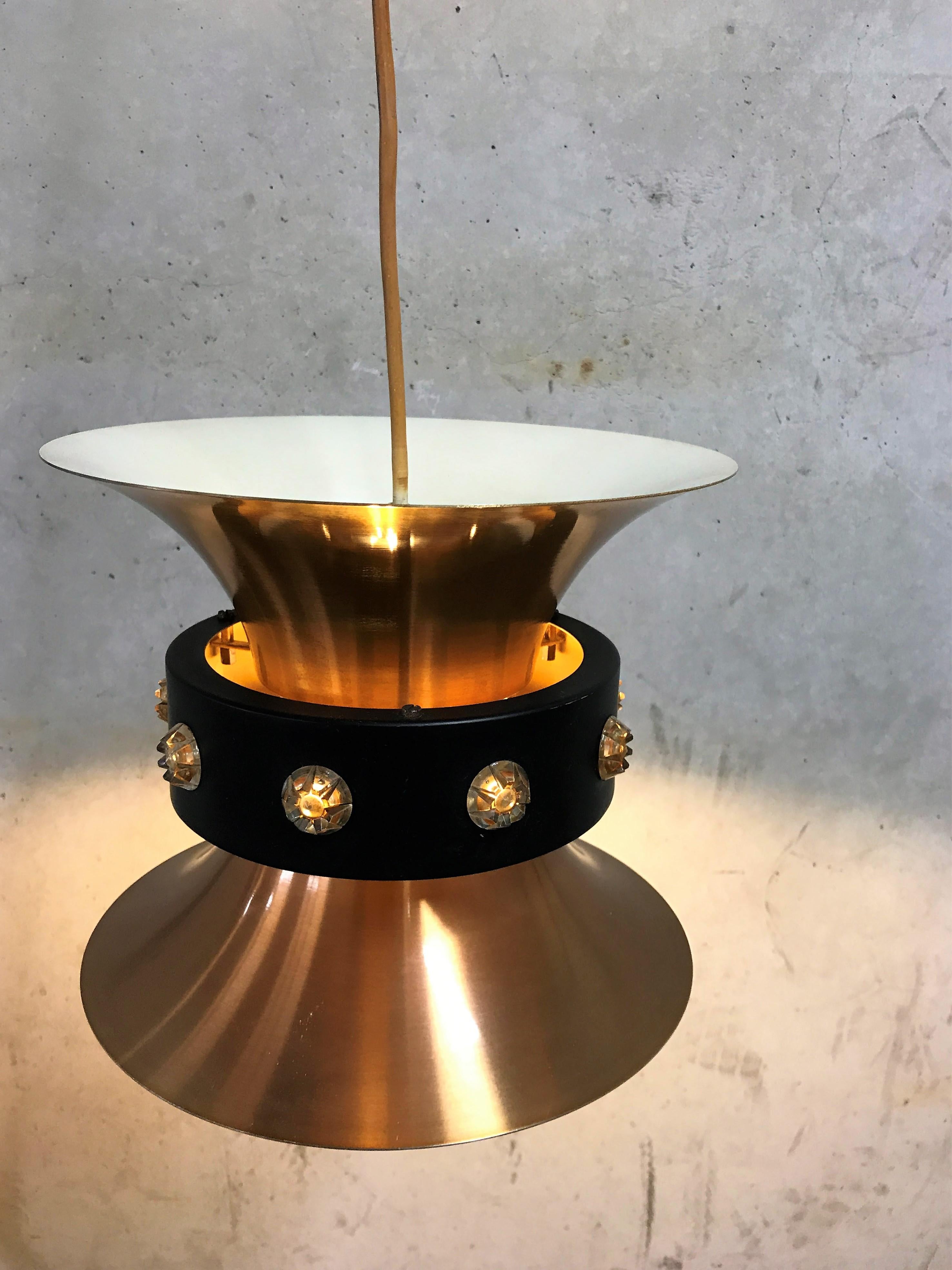 Brass pendant light by Carl Thore for Granhaga Metal Industry.

This beautiful Swedish design lamp was produced during the space age era in the late 1960s.

The diabolo shaped lamp produces a up-and downwards light/

Finished with a black ring