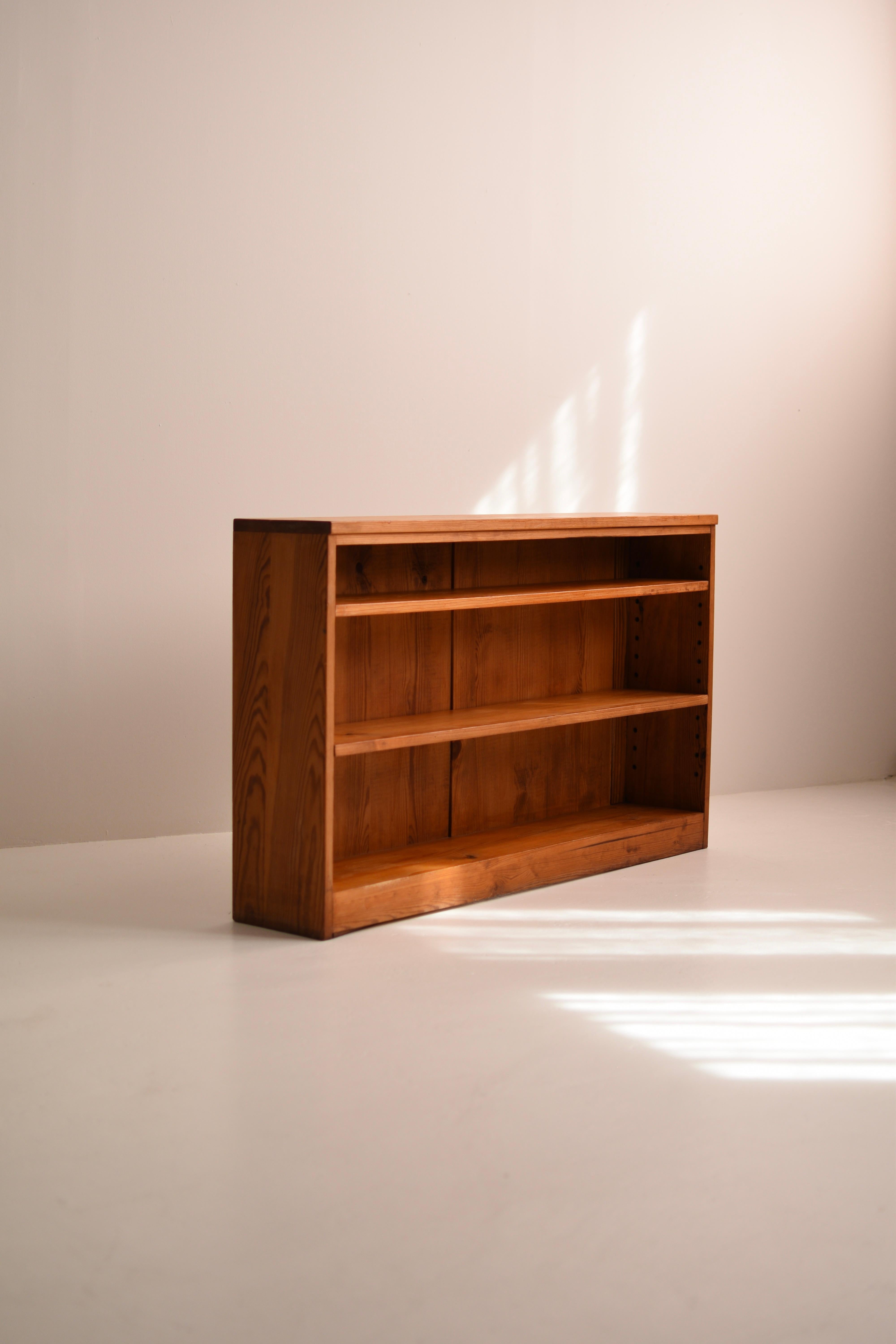 Questa libreria vintage Wood degli anni '30-'40 è realizzata in pino massiccio con una bella venatura del legno e una calda finitura color miele. 
Il suo design pulito e minimalista riflette il classico artigianato scandinavo, rendendolo un pezzo