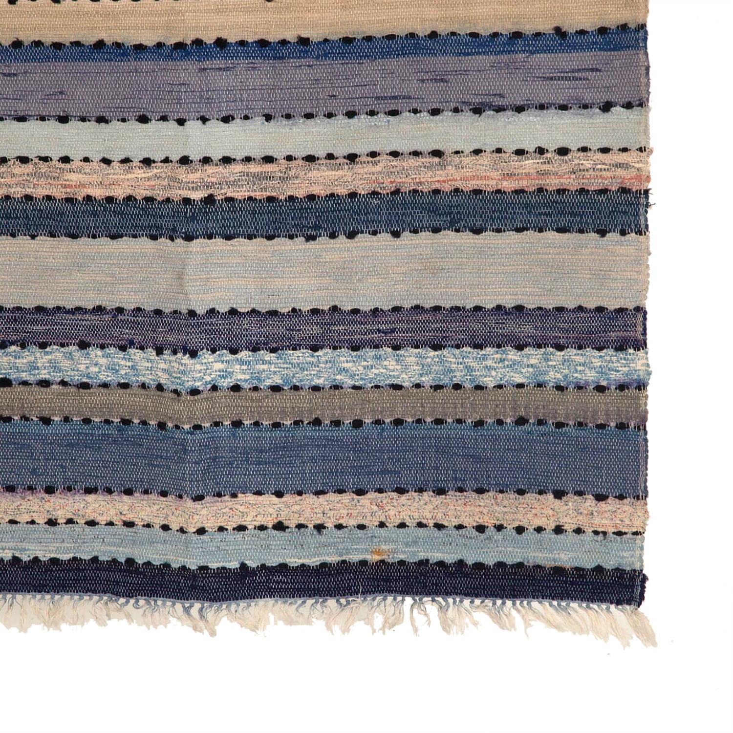 Swedish rug in soft faded colours with blue and earth tones. This piece was handwoven in the 1940s.