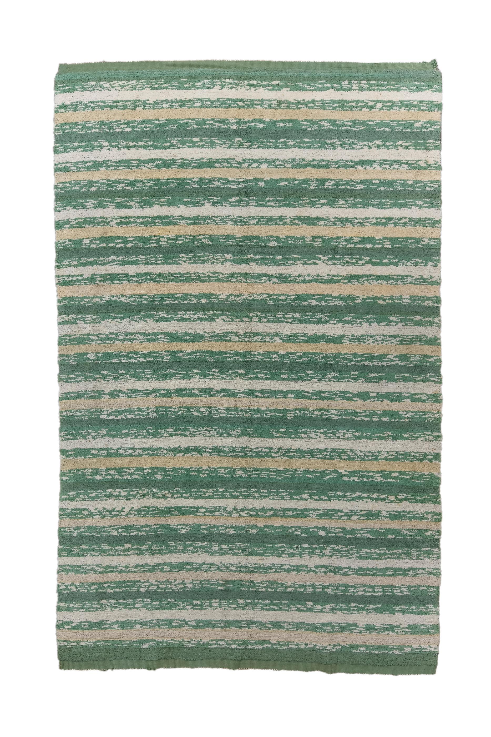A very minimal flatweave with a horizontal band design in which green is the reference color for the development of all the contrasts in ivory, beige and cream which make the entire graphic composition of this fantastic artefact dynamic. This type