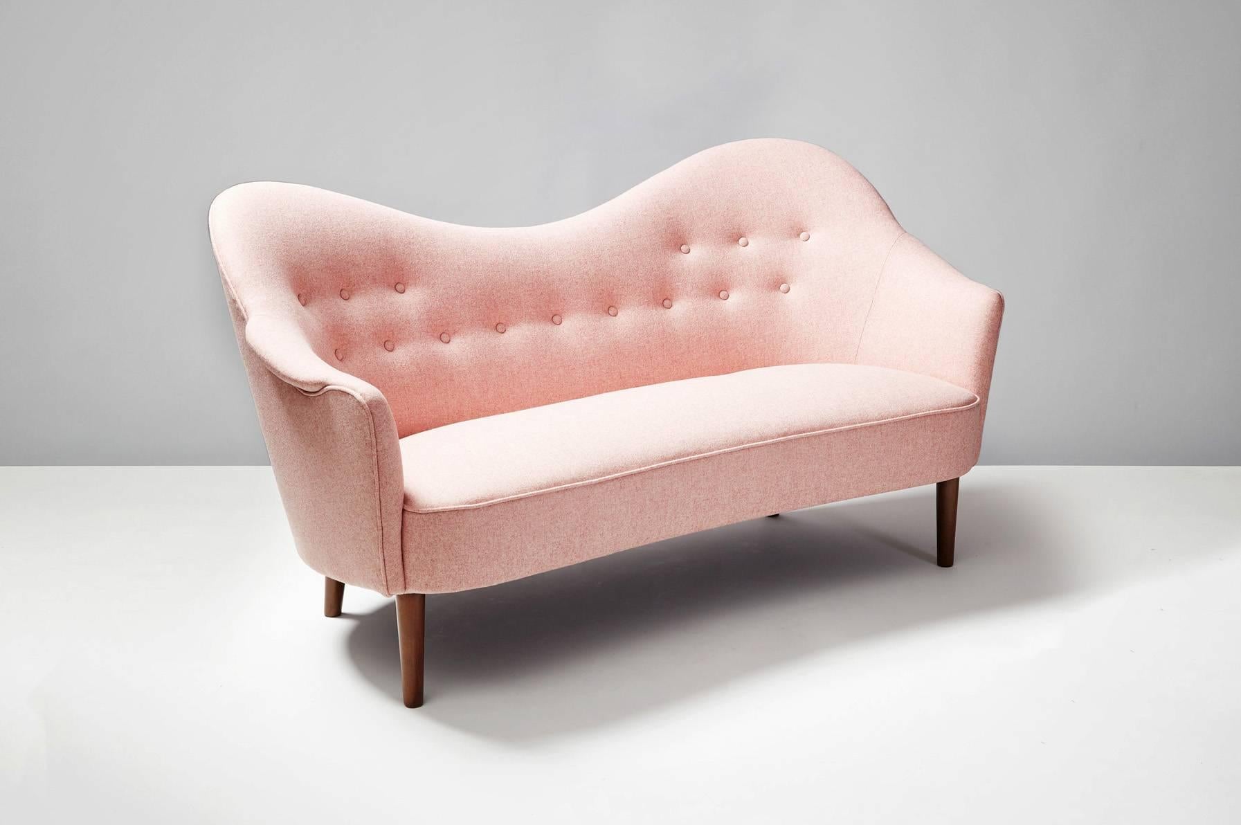 The Samspel 2-seat sofa was first designed in 1956 by Swedish master Carl Malmsten and produced by AB Record in Bollnas, Sweden. This example has been completely Reupholstered in dusty pink Abraham Melton wool fabric. The legs are turned,