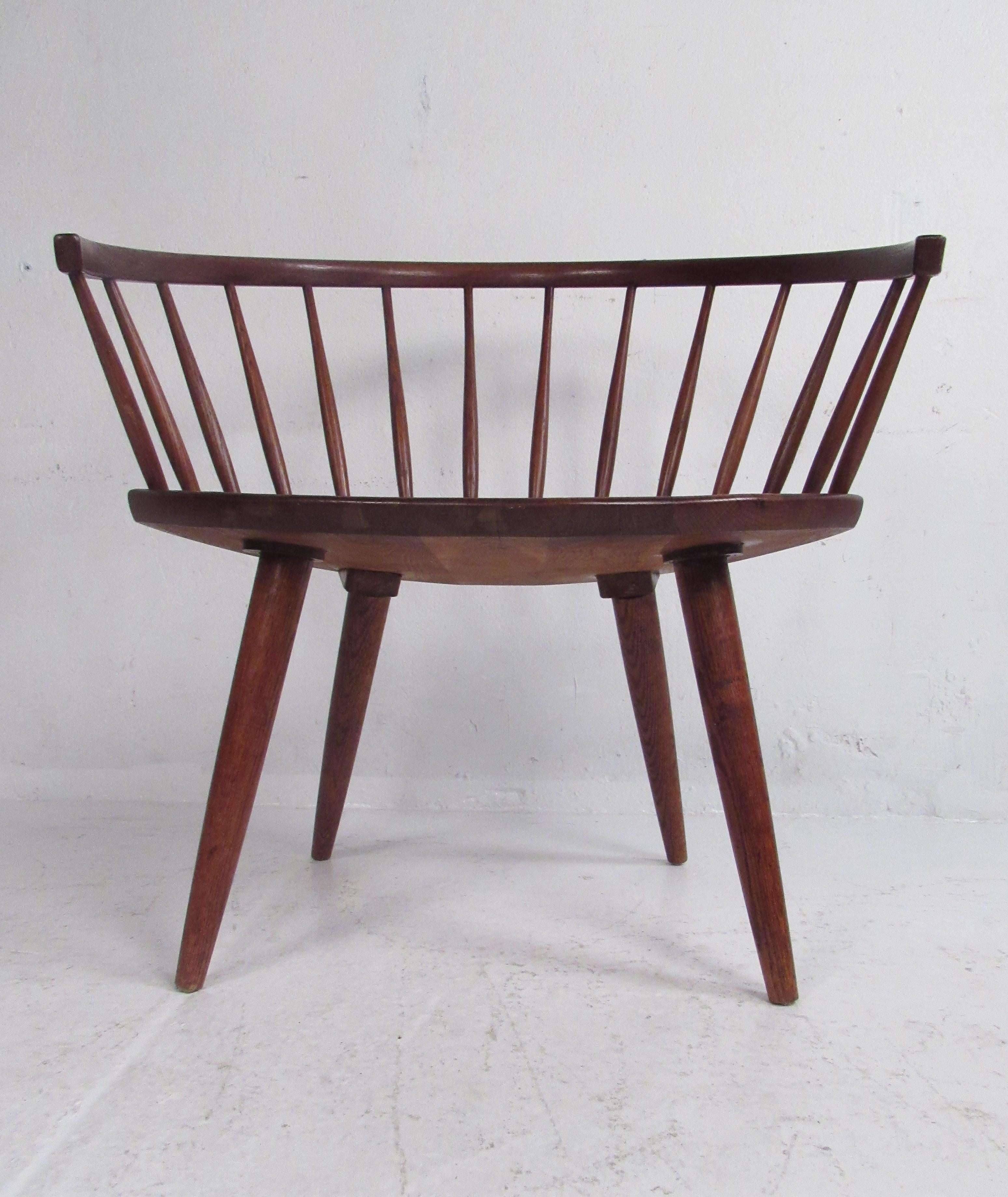 This wild Mid-Century Modern side chair boasts a barrel backrest with spindles and a sculpted seat. The splayed conical legs allow this chair to rest on a slight angle, ensuring maximum comfort. An exquisite design made of oak with luxurious wood