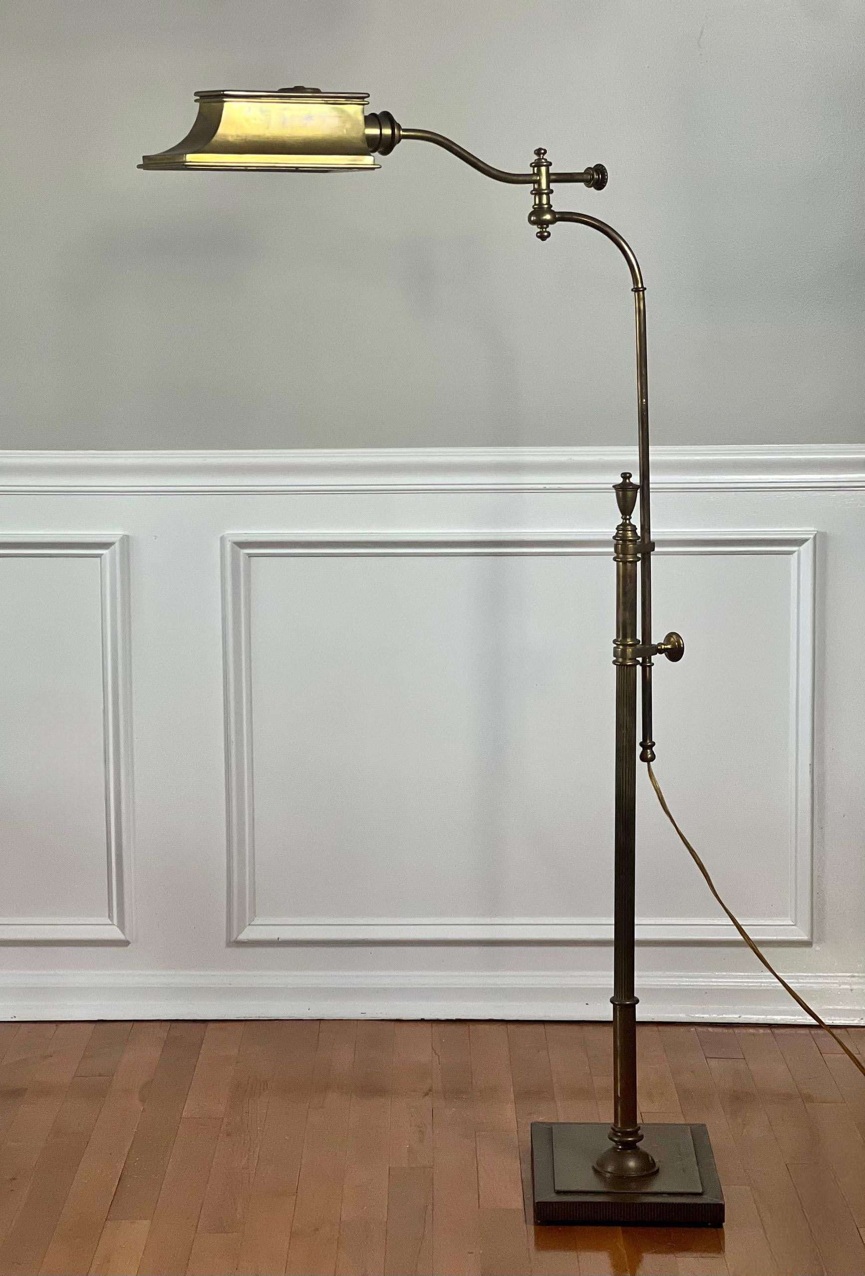 Excellent vintage midcentury brass pharmacy style floor lamp with swing arm and adjustable height. A super versatile piece in any room as it can be positioned in many configurations to suit your needs. It features a shapely brass hood shade, two